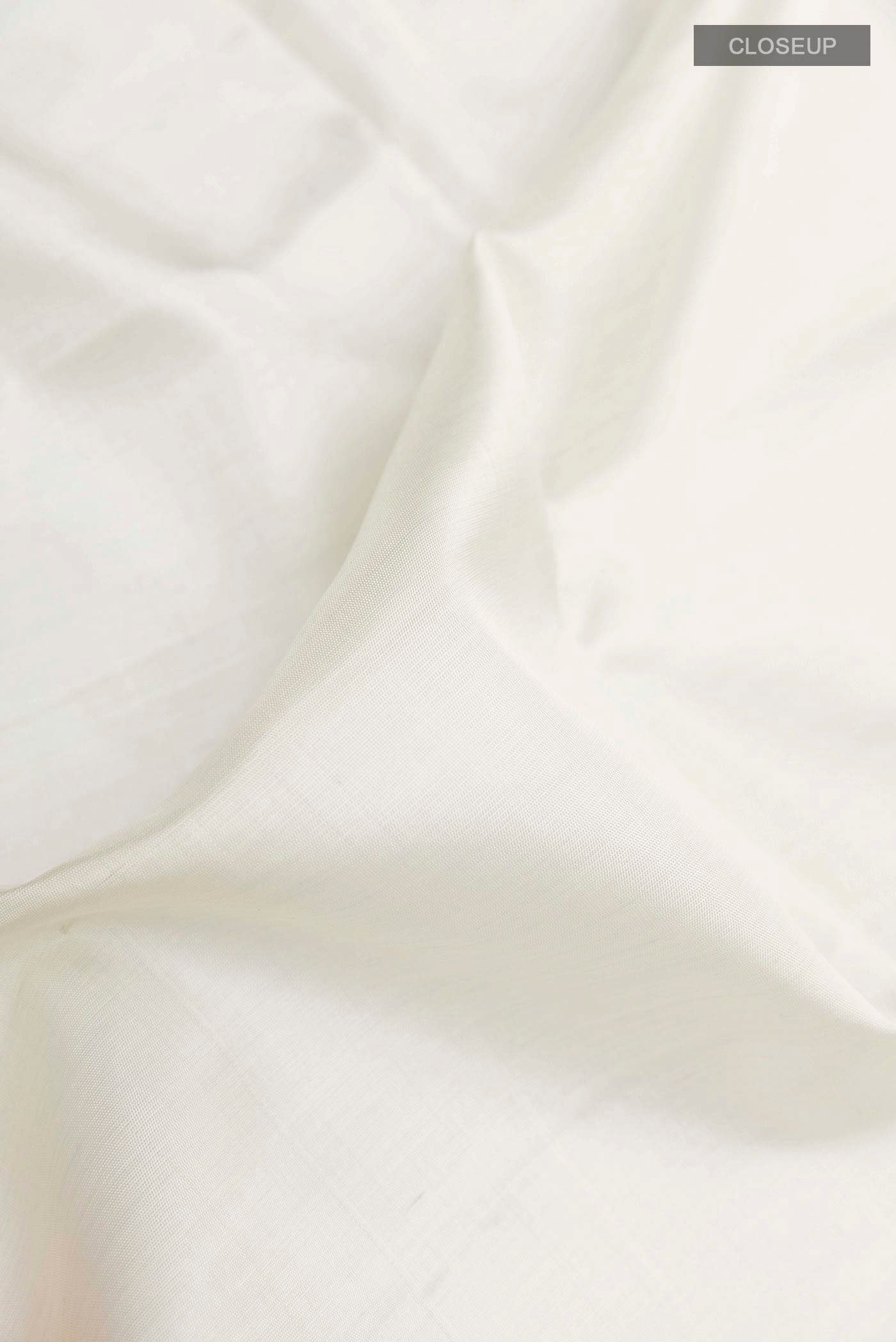 Close up of Off White Soft Silk Saree with Plain Body and Zari Border displaying folds