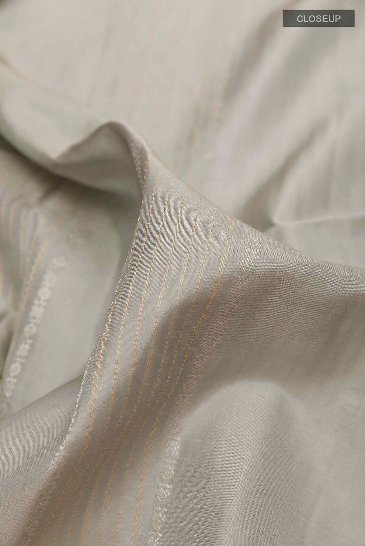 Close up of Grey Soft Silk Saree with Stripes on the body and Zari Border displaying folds