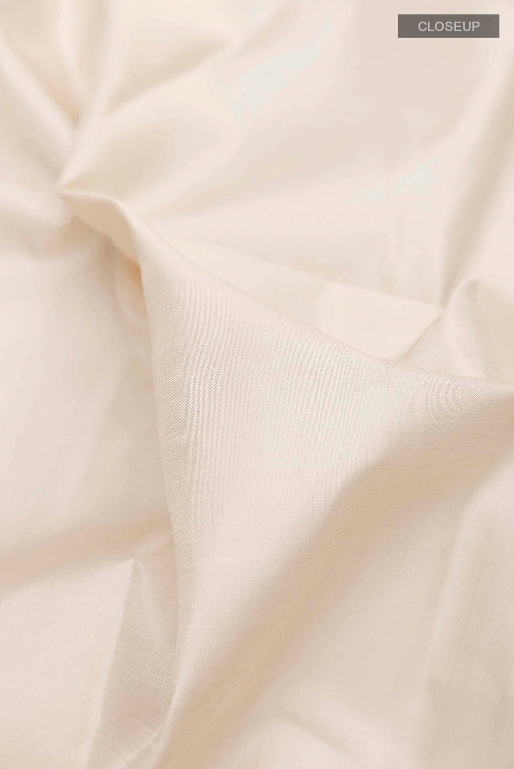 Close up of Off White Kanchipuram Silk Saree with Plain Body and Zari Border displaying folds
