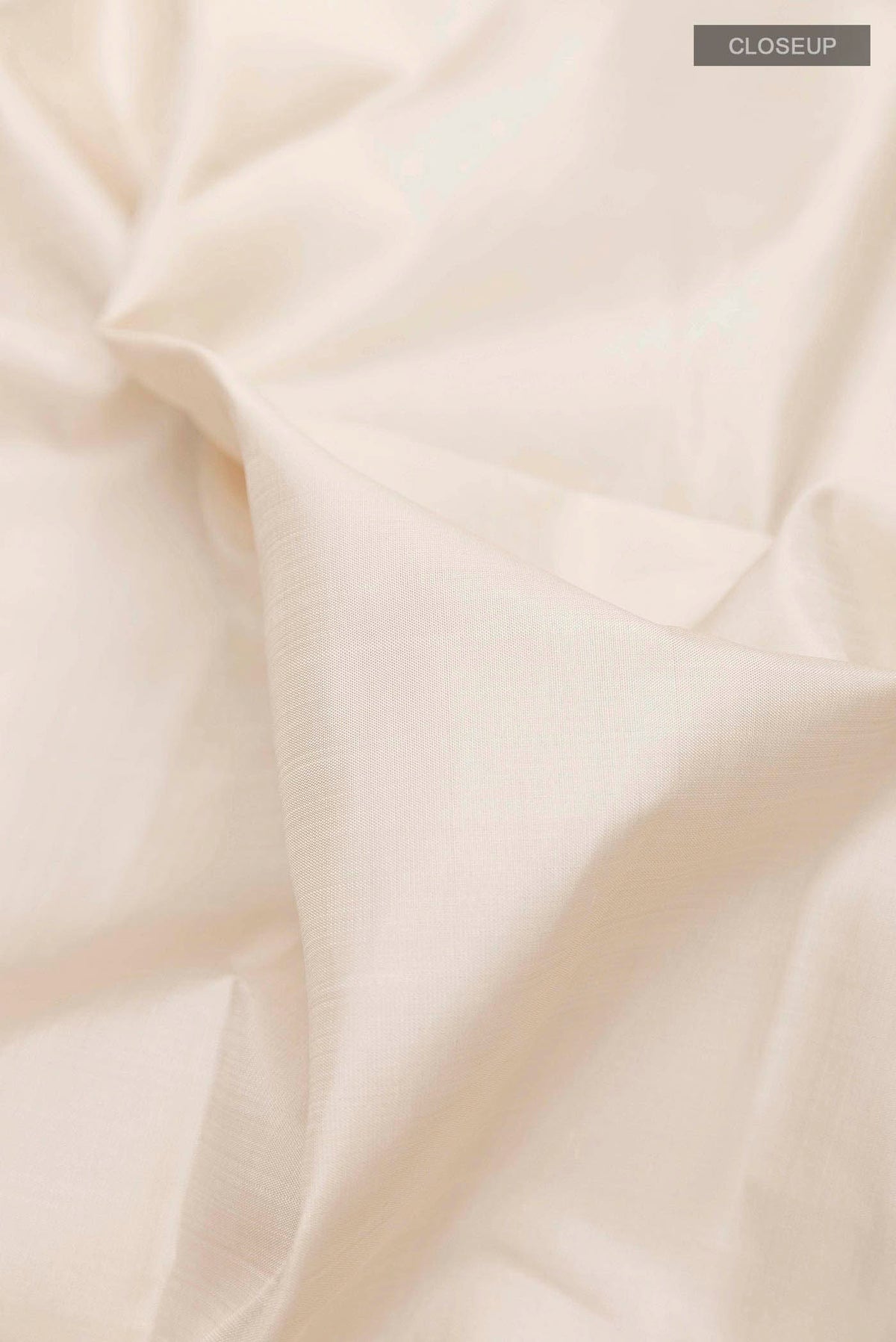 Close up of Off White Kanchipuram Silk Saree with Plain Body and Zari Border displaying folds