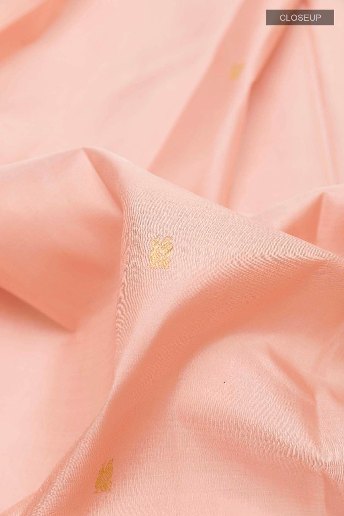 Close up of Rose pink Kanchipuram Silk Saree with Zari Butta on the body and Zari Border displaying folds