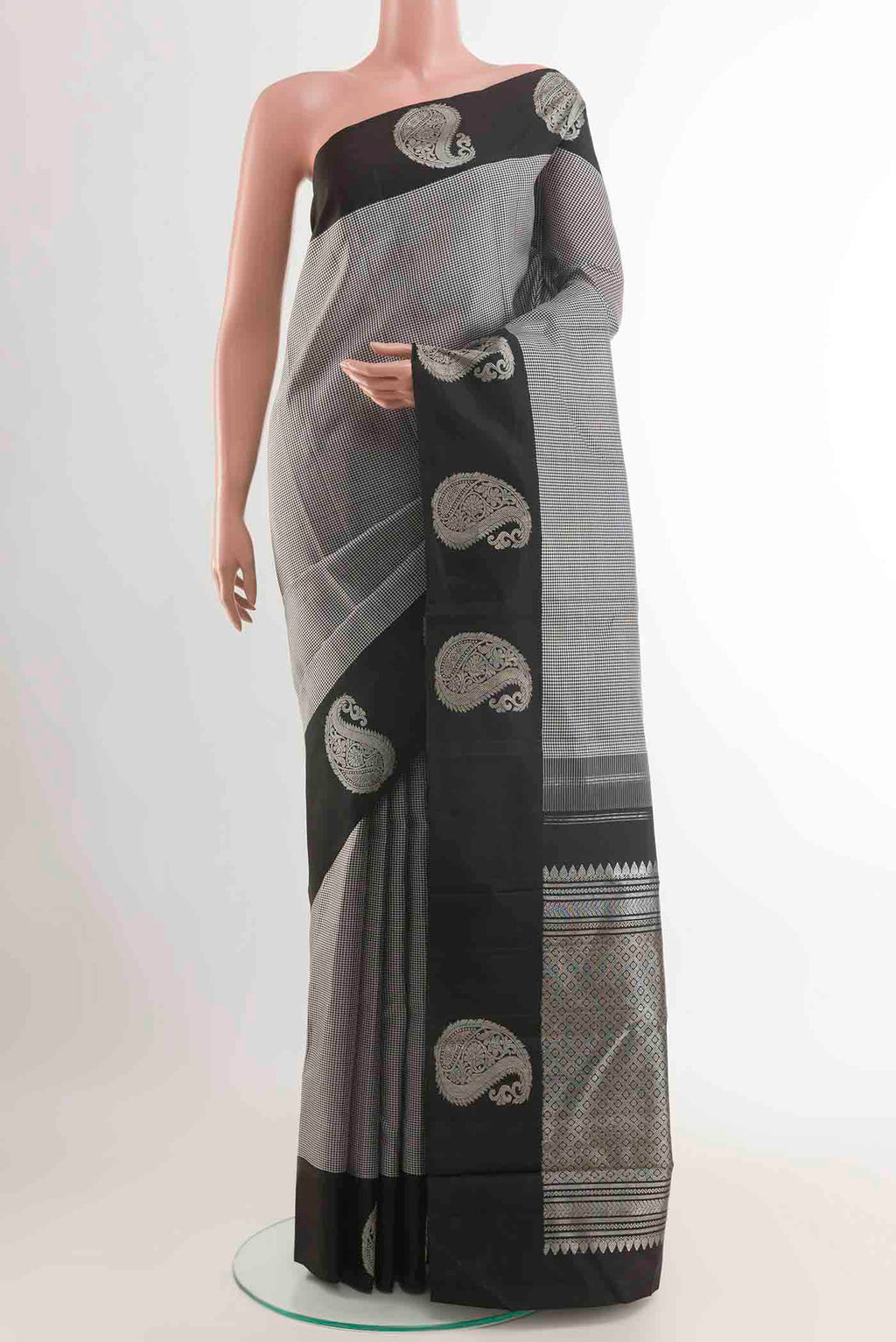 White Kanchipuram Silk Saree with Checked design on the body and Zari Border displayed on a mannequin