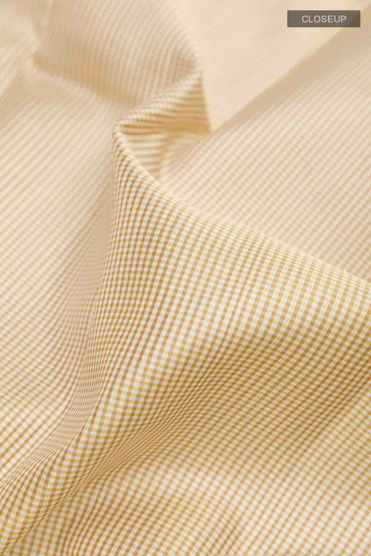 Close up of Off White Kanchipuram Silk Saree with Checked design on the body and Zari Border displaying folds