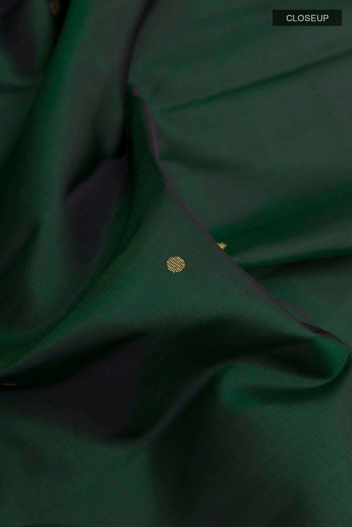 Close up of Bottle Green Kanchipuram Silk Saree with Zari Butta on the body and Zari Border displaying folds