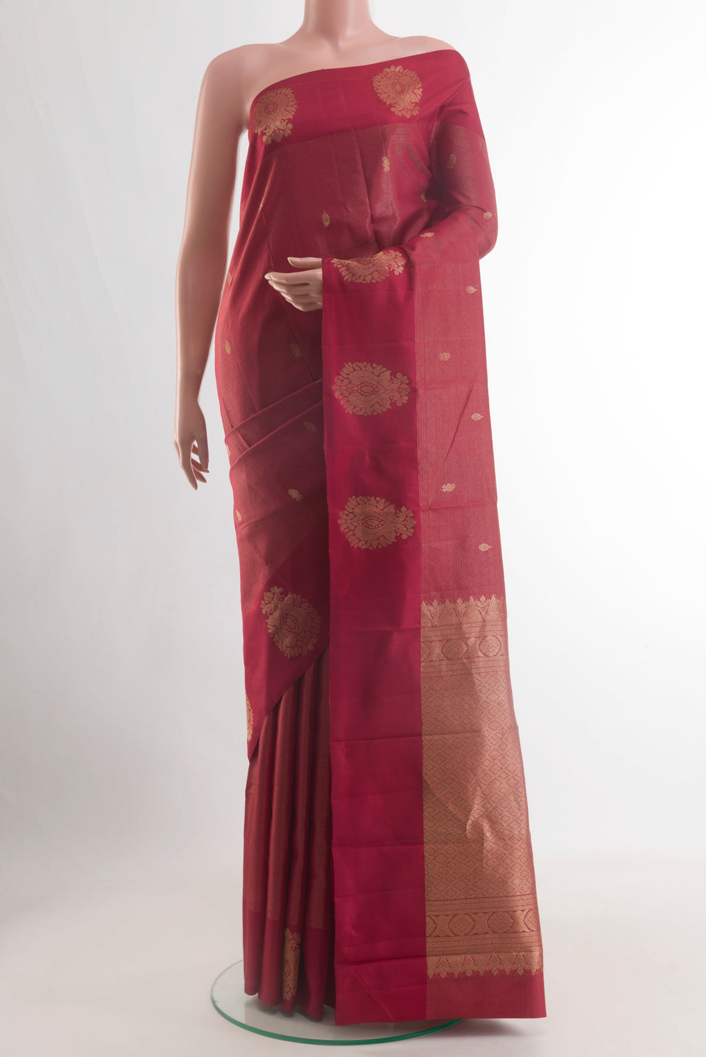 Maroon Kanchipuram Silk Saree with Zari Butta on the body and Zari Border.  displayed on a mannequin