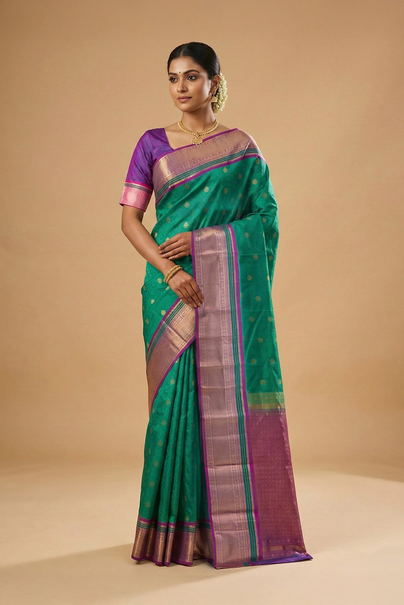 Model wearing a Turquoise Kanchipuram Silk Saree with Jacquard With Zari Butta on the body and Zari Border.