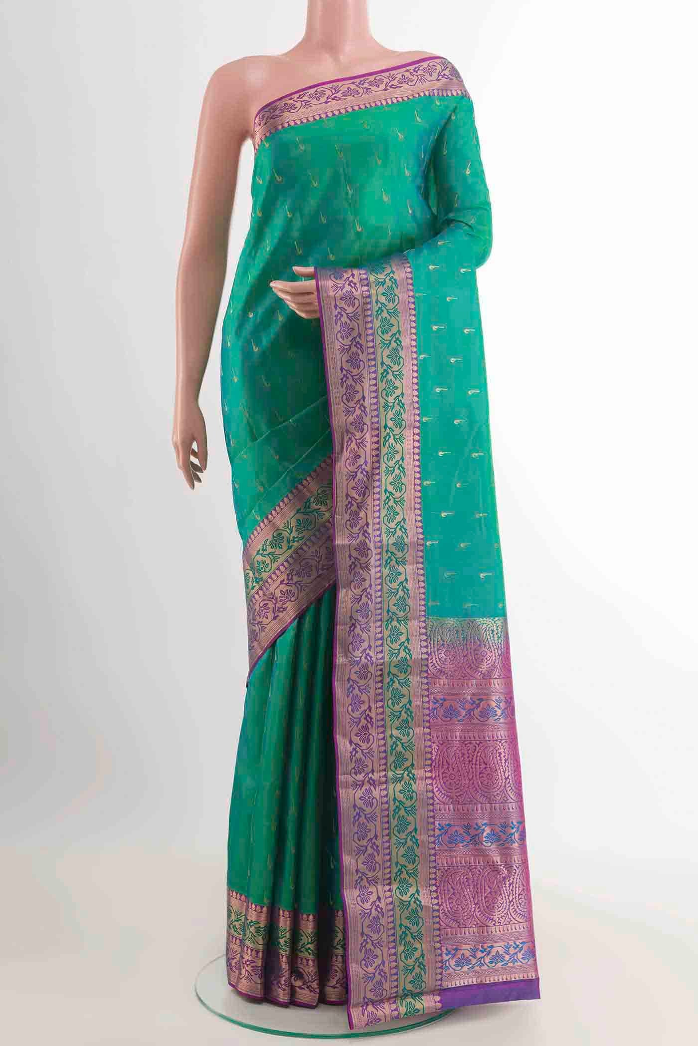 Green Kanchipuram Silk Saree with Zari Butta on the body and Zari Border displayed on a mannequin