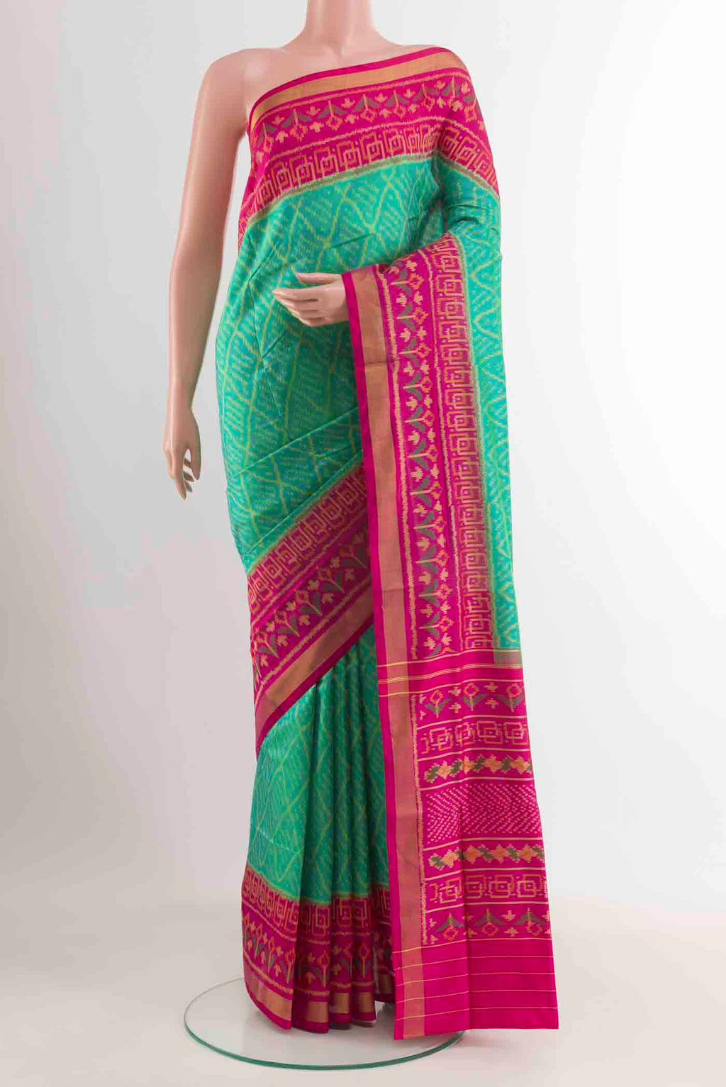 Green Rajkot Patola Silk Saree with Ikat design on the body and Zari Border displayed on a mannequin