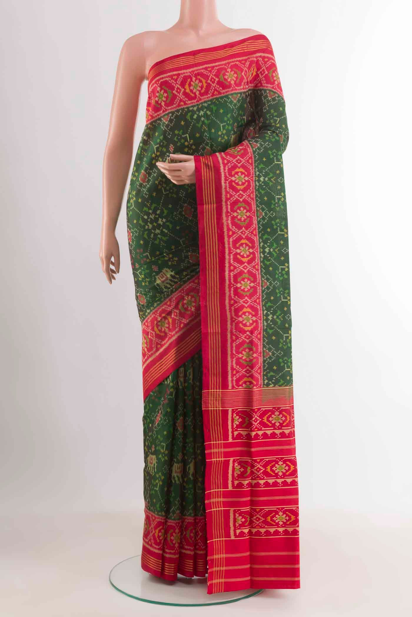 Green Rajkot Patola Silk Saree with Ikat design on the body and Zari Border displayed on a mannequin