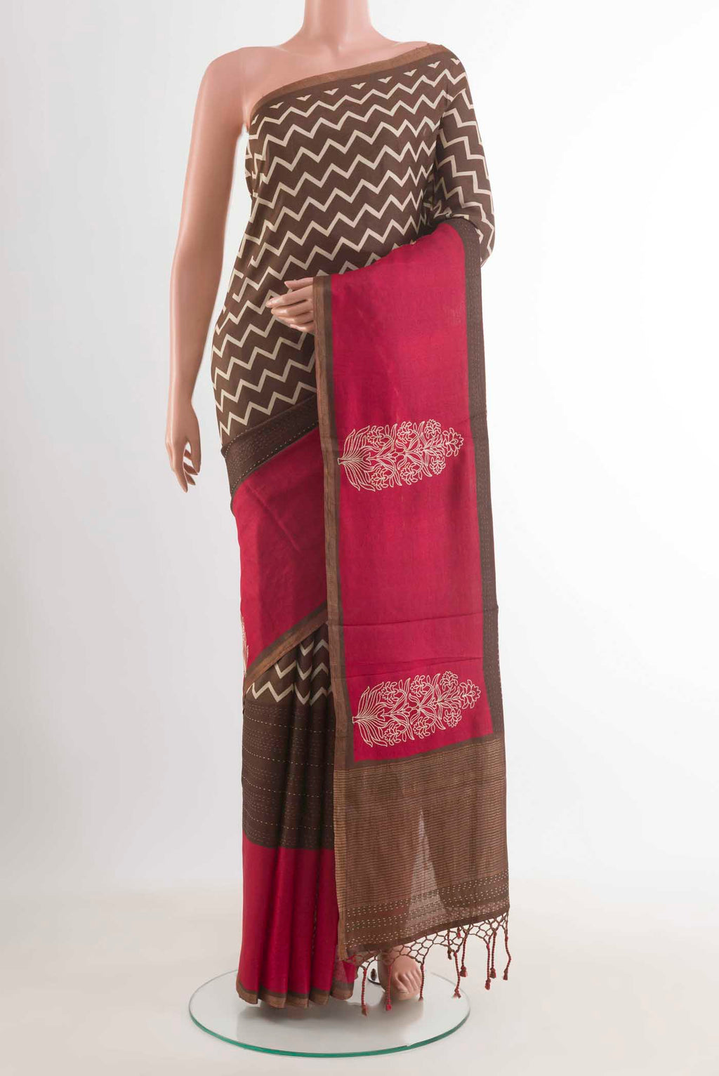 Brown Tussar Silk Saree with Zig Zag design on the body and Zari Border displayed on a mannequin