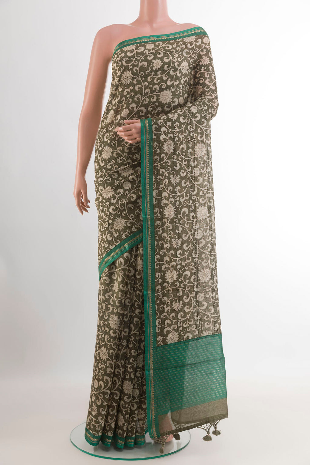 Mehandi Green Tussar Saree with Printed design on the body and Zari Border.  displayed on a mannequin