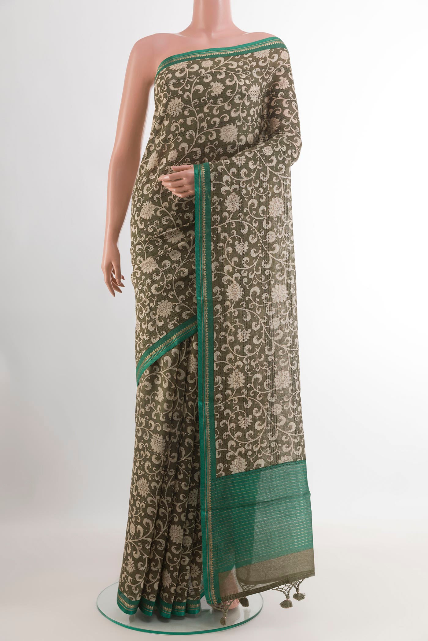 Mehandi Green Tussar Saree with Printed design on the body and Zari Border.  displayed on a mannequin