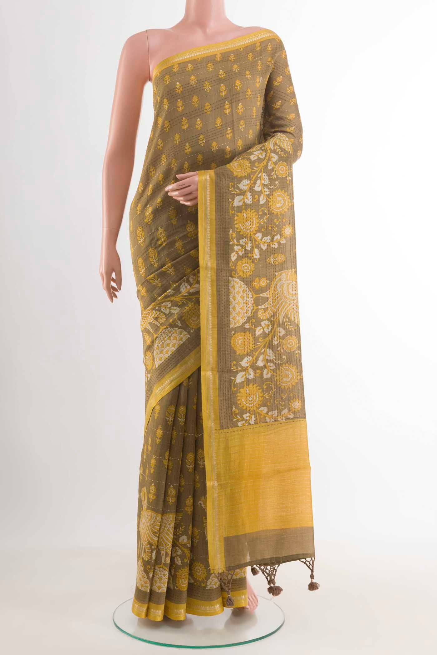 Beige Tussar Saree with Printed design on the body and Zari Border displayed on a mannequin