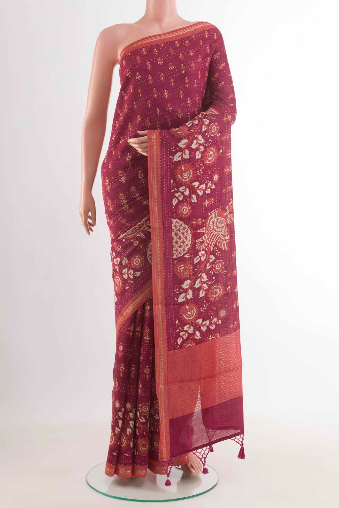 Magenta Tussar Silk Saree with Printed design on the body and Zari Border displayed on a mannequin