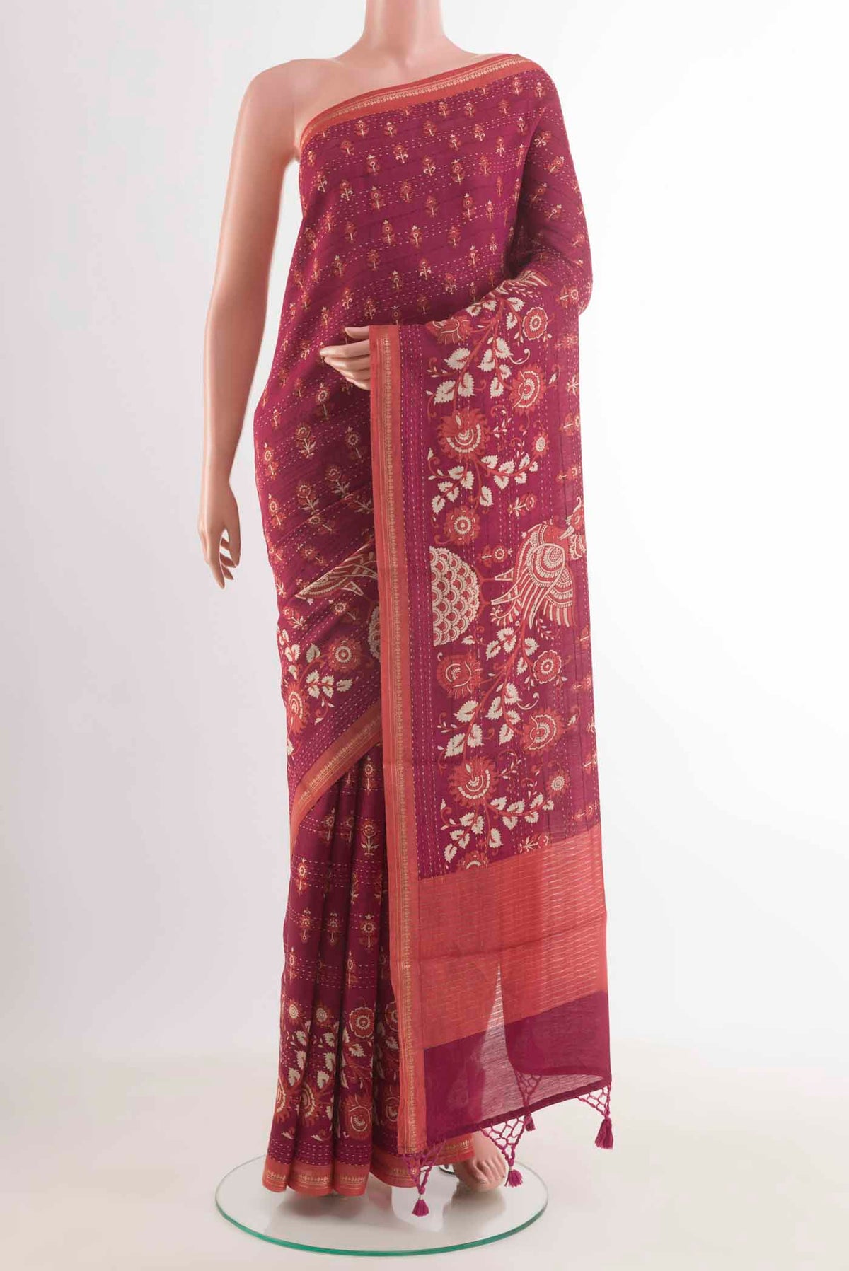 Magenta Tussar Silk Saree with Printed design on the body and Zari Border displayed on a mannequin