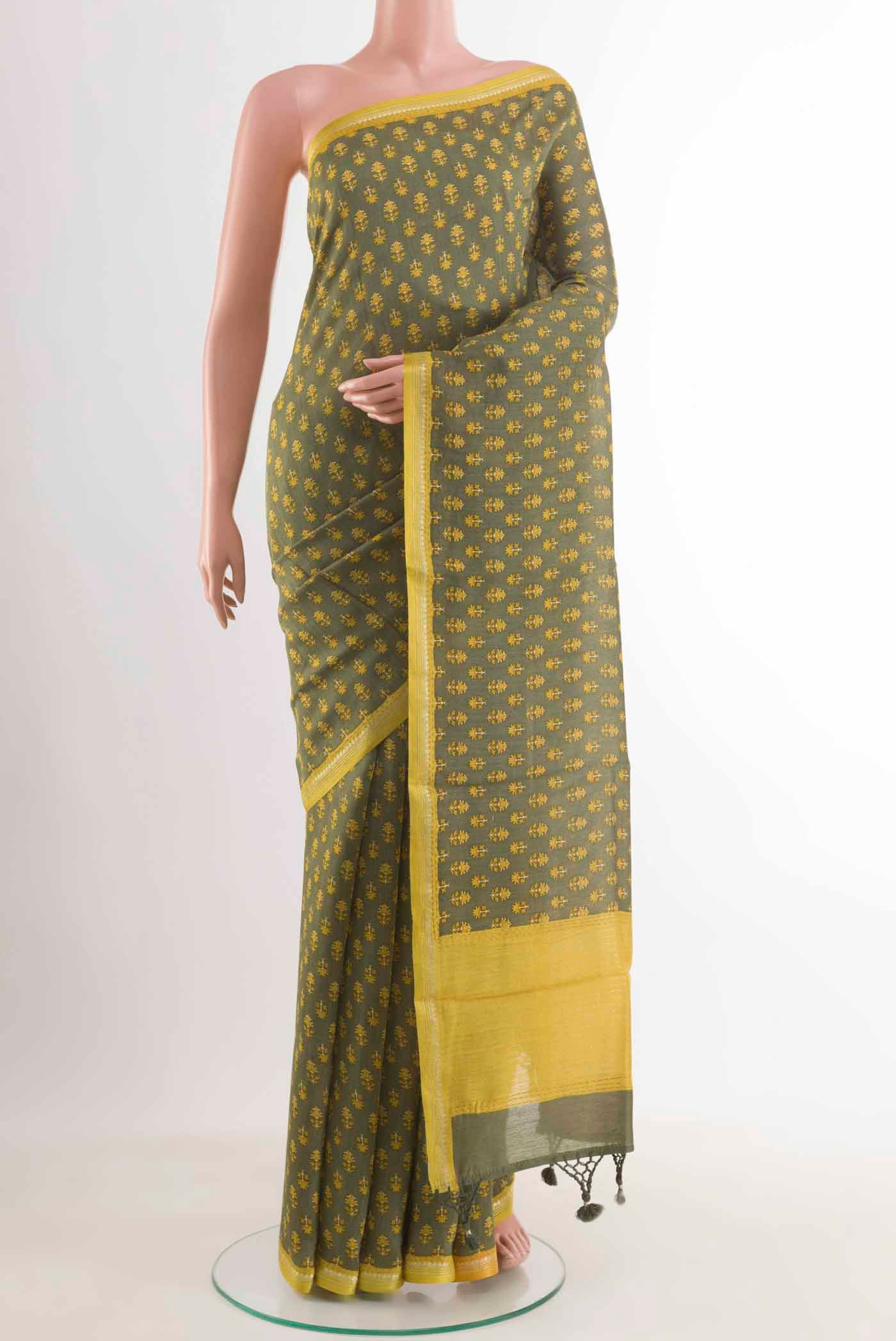 Sage Green Tussar Silk Saree with Printed design on the body and Zari Border displayed on a mannequin