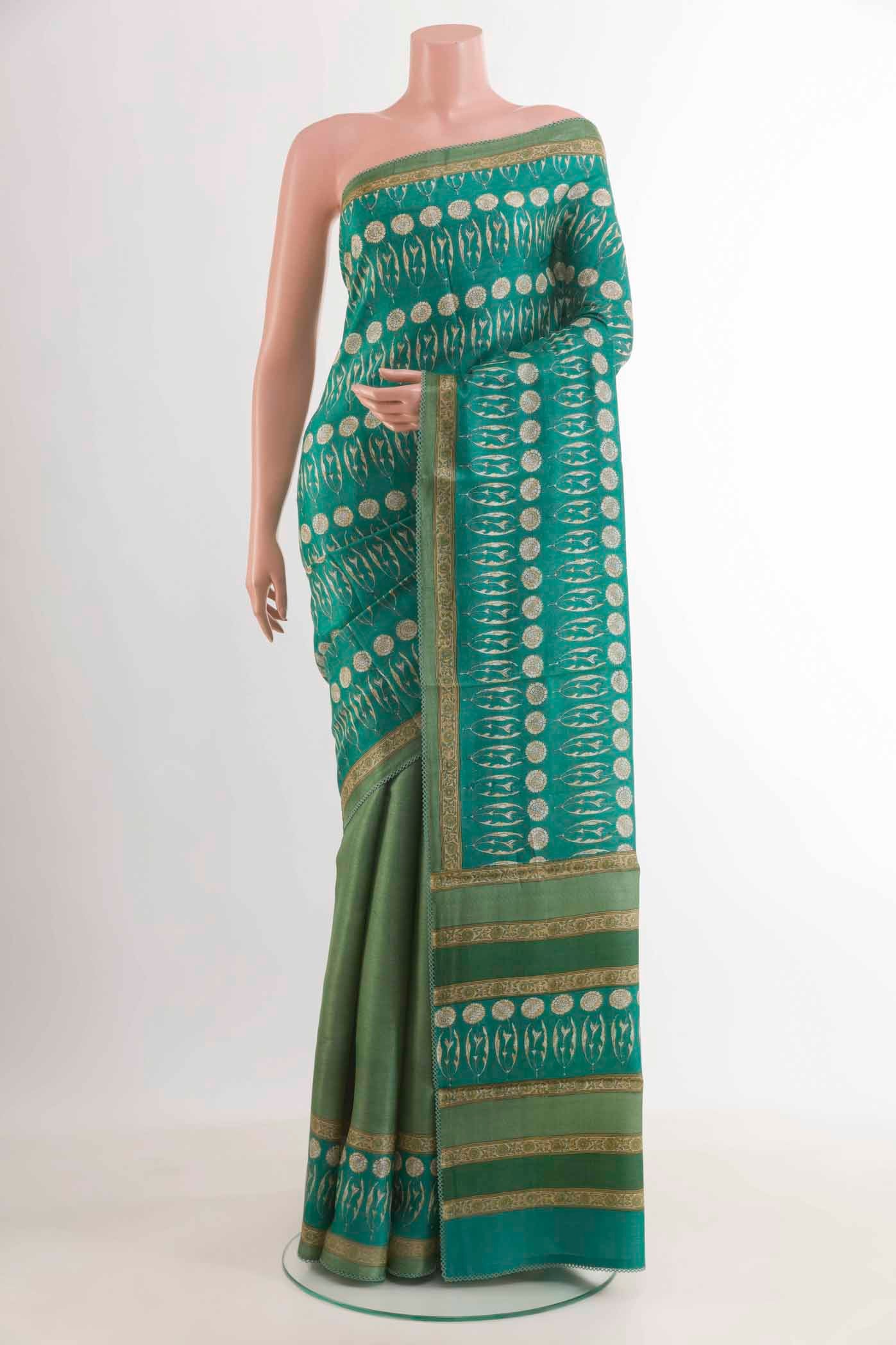 Green Tussar Saree with Printed design on the body and Printed Border.  displayed on a mannequin