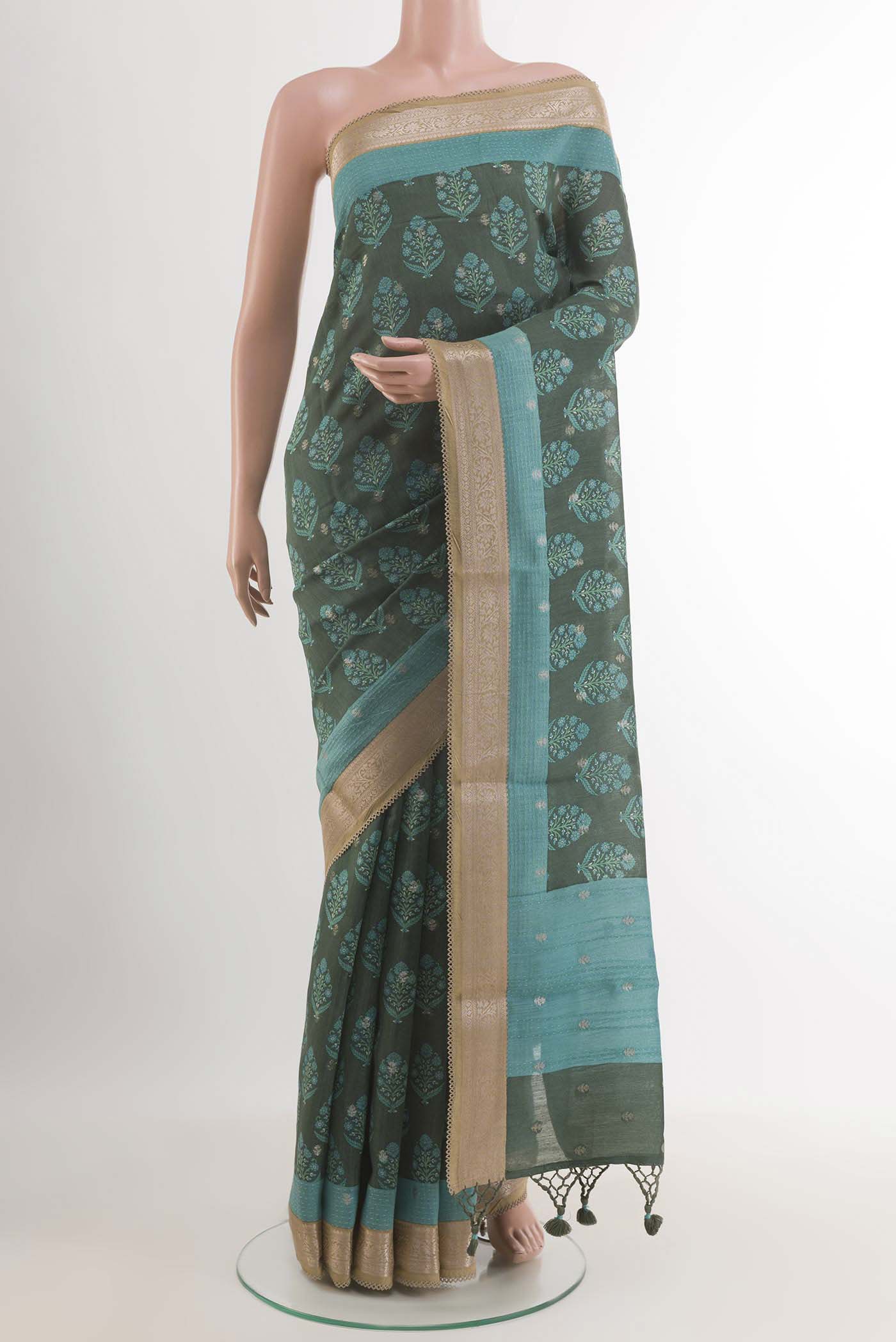 Green Tussar Saree with Printed design on the body and Zari Border.  displayed on a mannequin