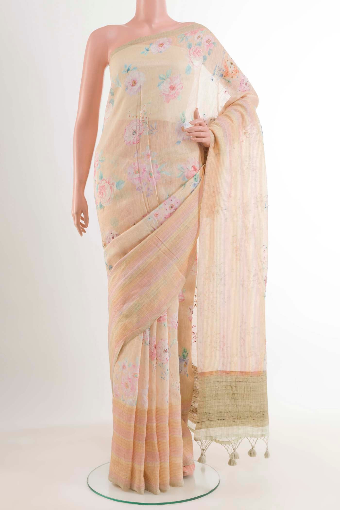 Peach Linen Saree with Printed design on the body and Zari Border.  displayed on a mannequin