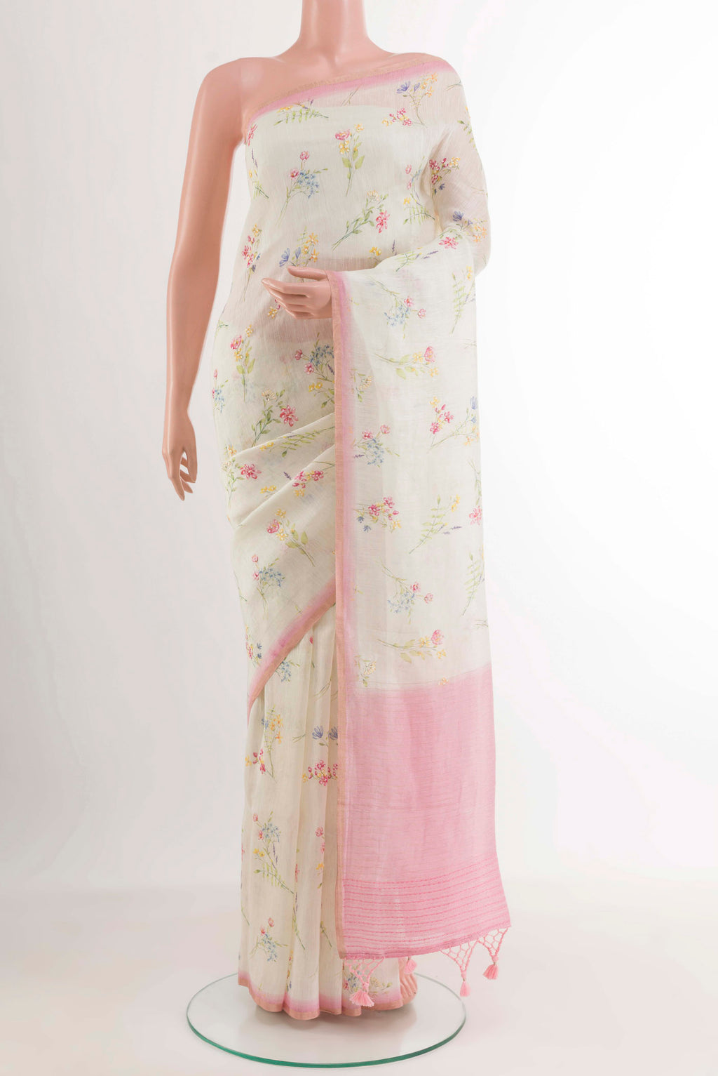 Off White Linen Saree with Printed design on the body and Zari Border.  displayed on a mannequin