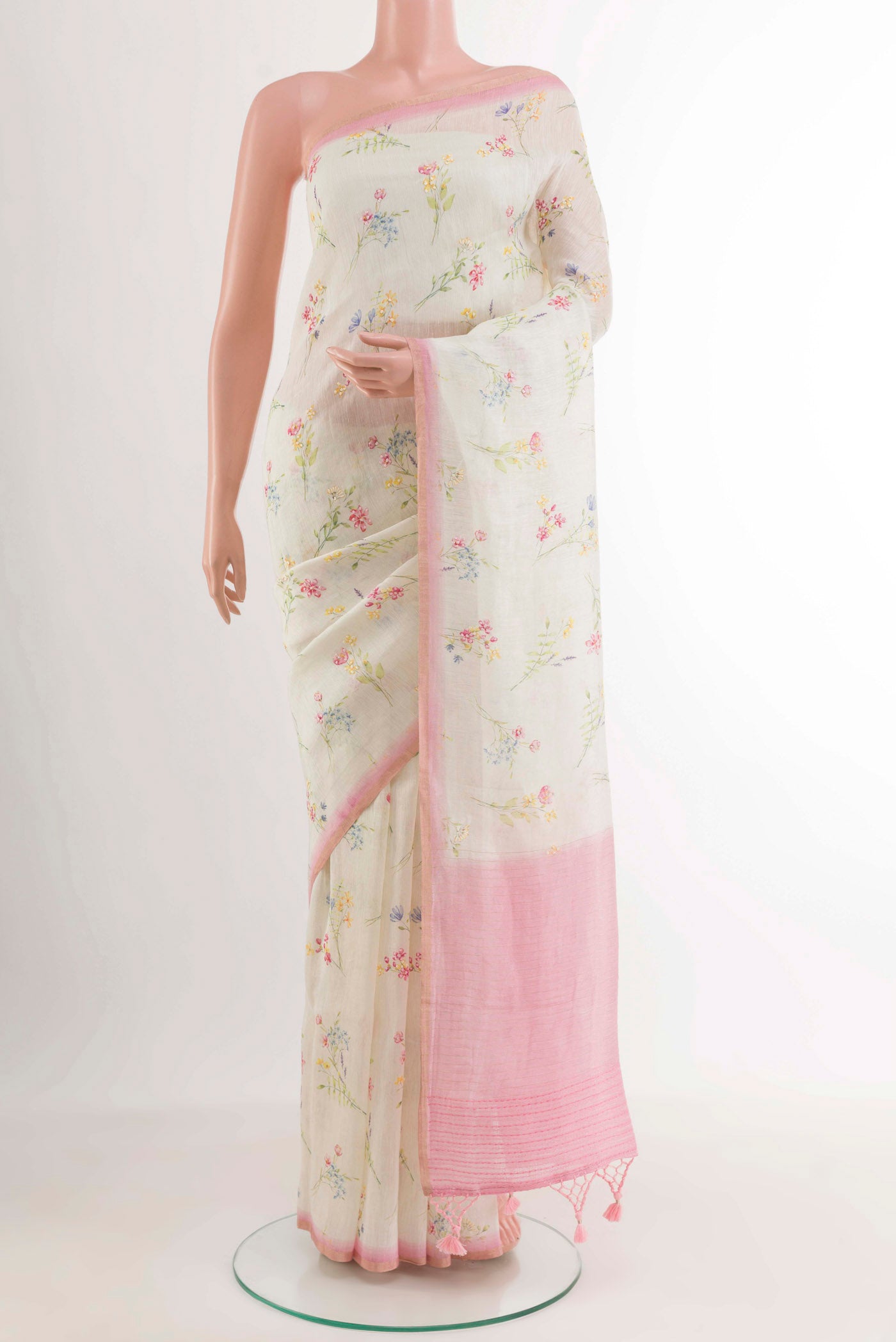 Off White Linen Saree with Printed design on the body and Zari Border.  displayed on a mannequin