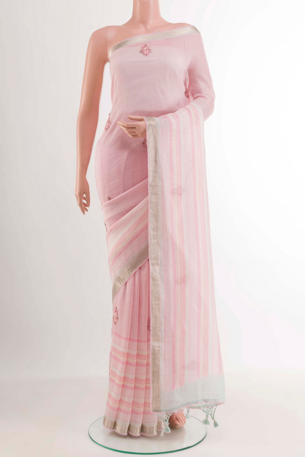 White Linen Saree with Embroidery on the body and Zari Border.  displayed on a mannequin