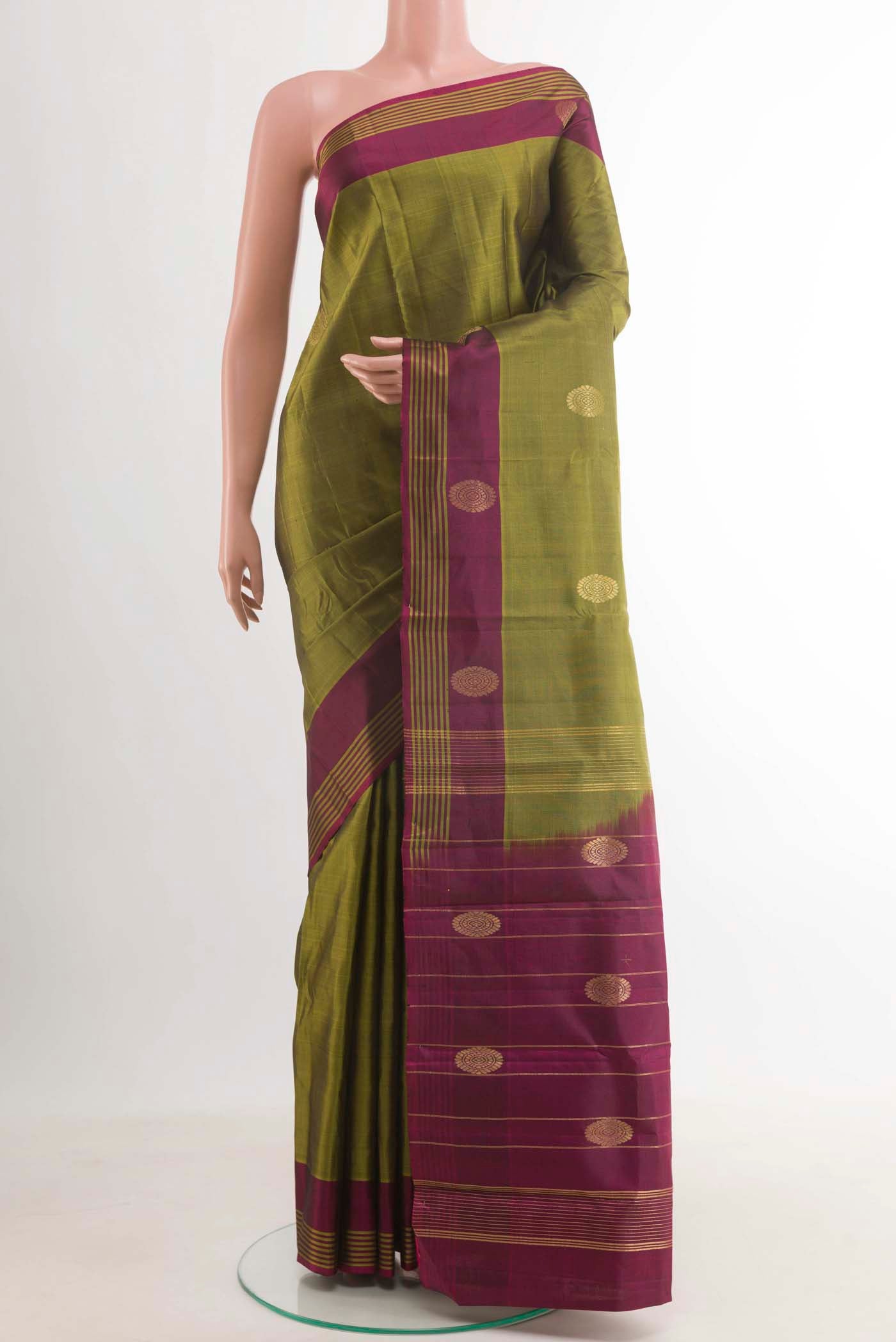 Mehandi Green Kanchipuram Silk Saree with Zari Butta on the body and Zari Border.  displayed on a mannequin