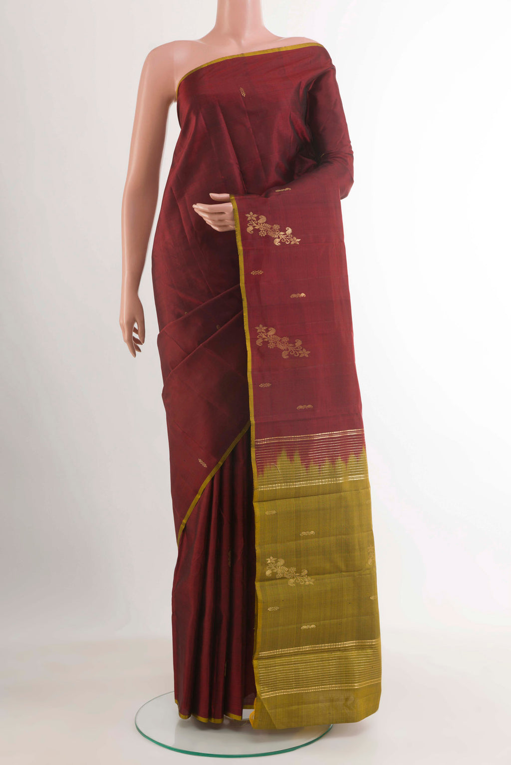 Maroon Kanchipuram Silk Saree with Zari Butta on the body and Zari Border.  displayed on a mannequin