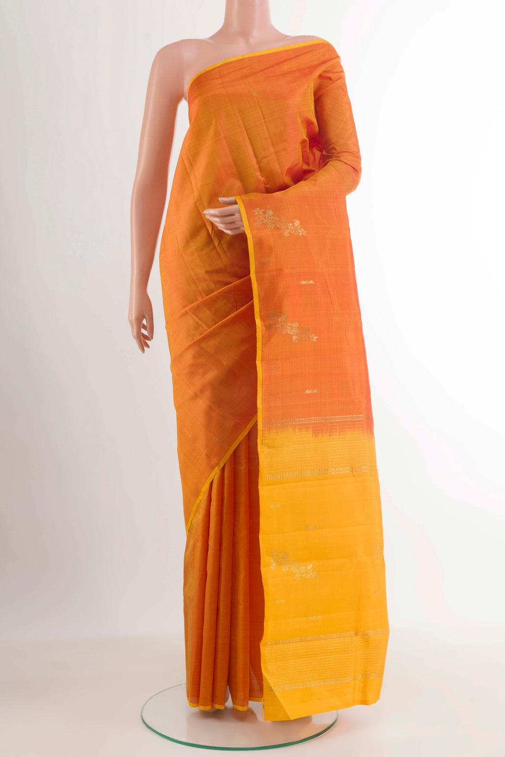 Mustard Kanchipuram Silk Saree with Zari Butta on the body and Zari Border.  displayed on a mannequin
