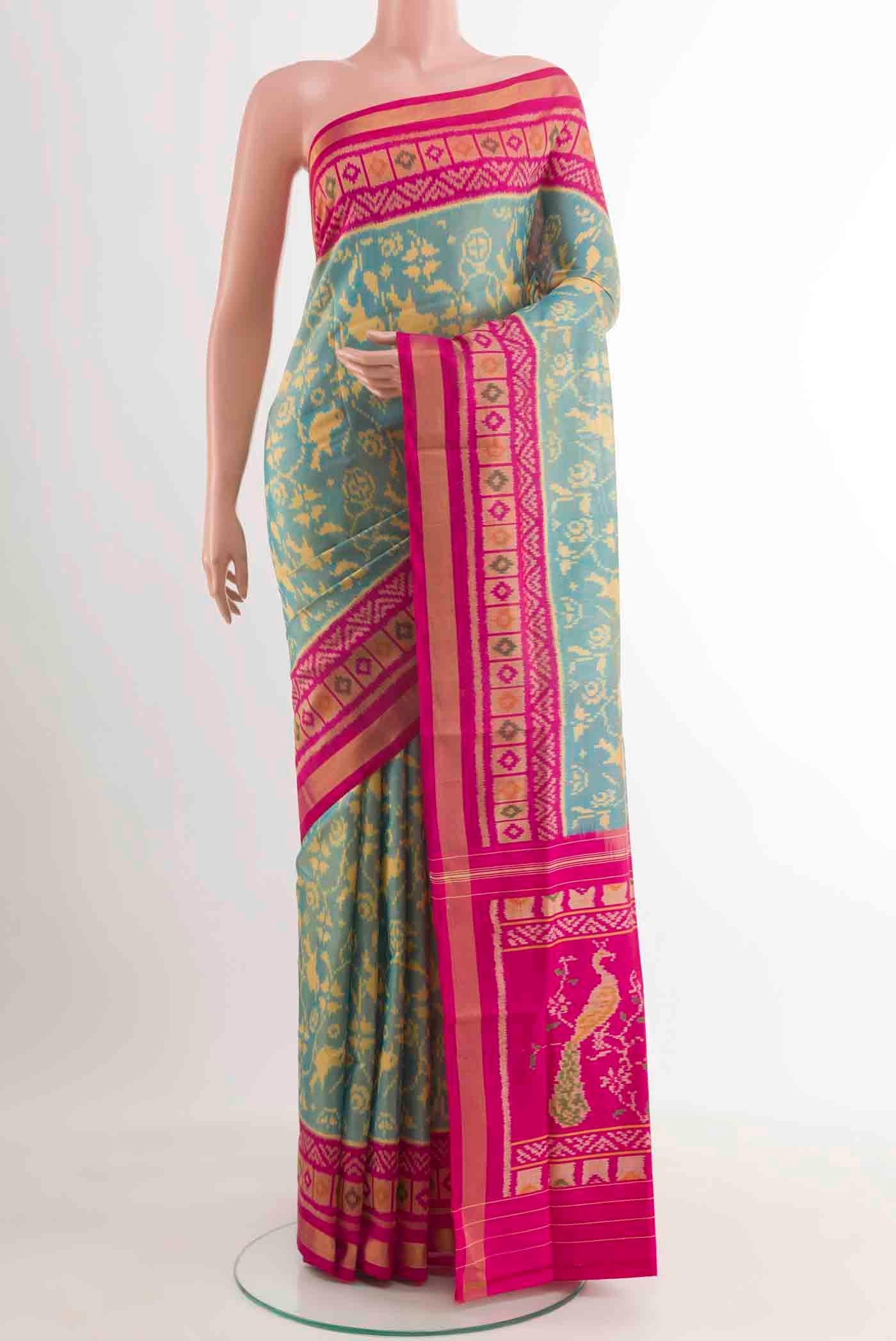 Teal Rajkot Patola Silk Saree with Pure Ikat on the body and Zari Border.  displayed on a mannequin