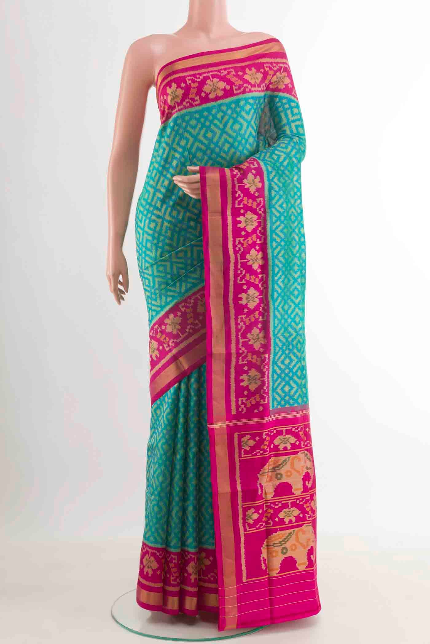 Green Rajkot Patola Silk Saree with Pure Ikat on the body and Zari Border.  displayed on a mannequin