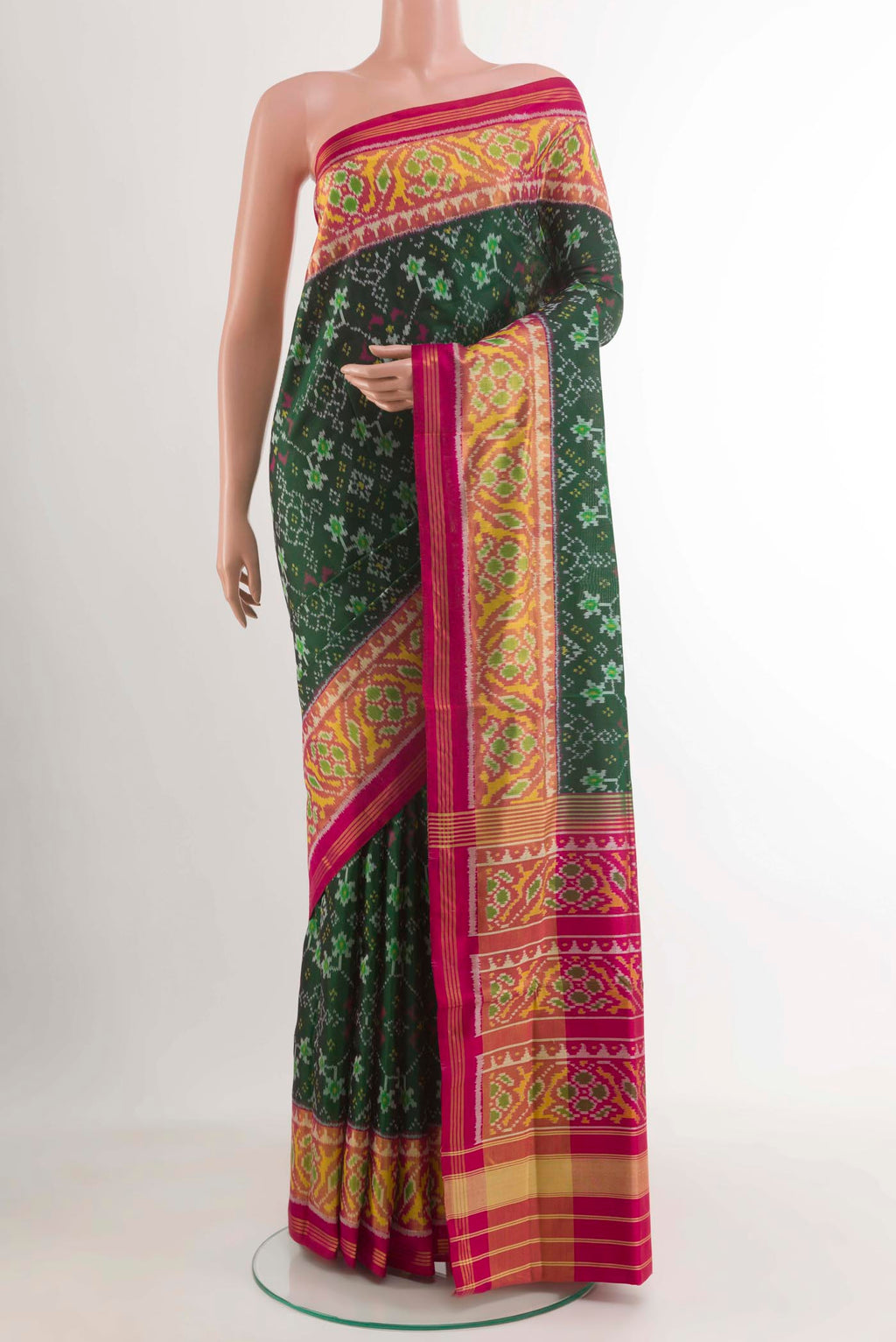 Bottle Green Rajkot Patola Silk Saree with Ikat design on the body and Zari Border.  displayed on a mannequin