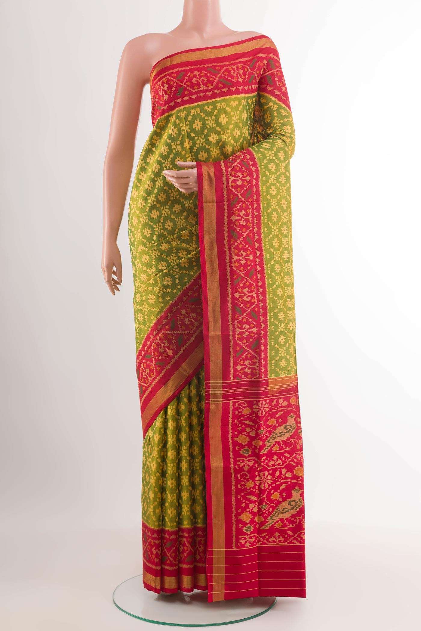 Green Rajkot Patola Silk Saree with Ikat design on the body and Zari Border.  displayed on a mannequin
