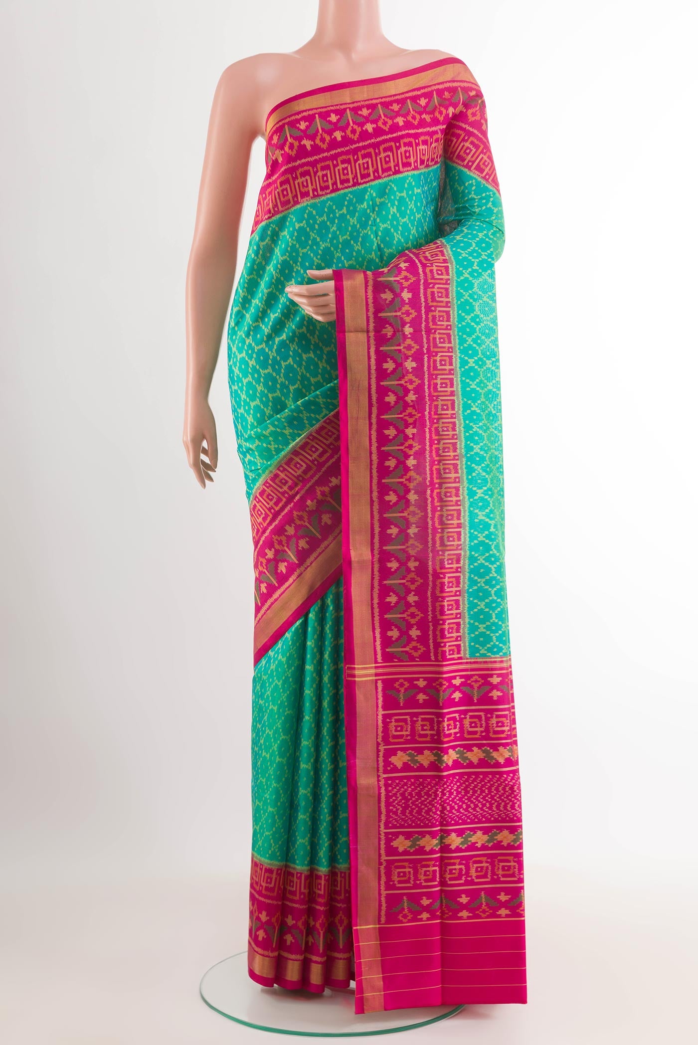 Green Rajkot Patola Silk Saree with Ikat design on the body and Zari Border.  displayed on a mannequin