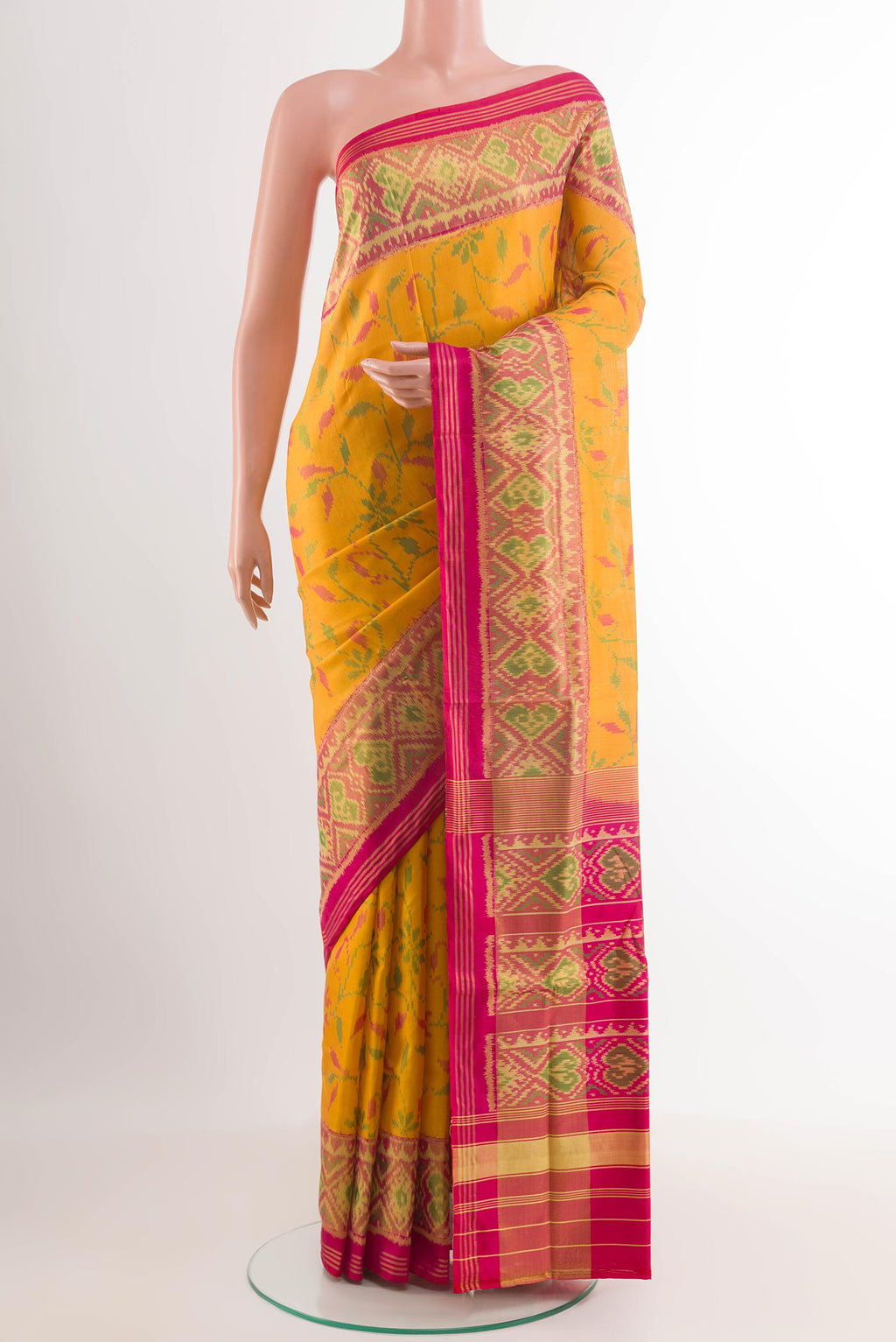 Yellow Rajkot Patola Silk Saree with Ikat design on the body and Zari Border.  displayed on a mannequin
