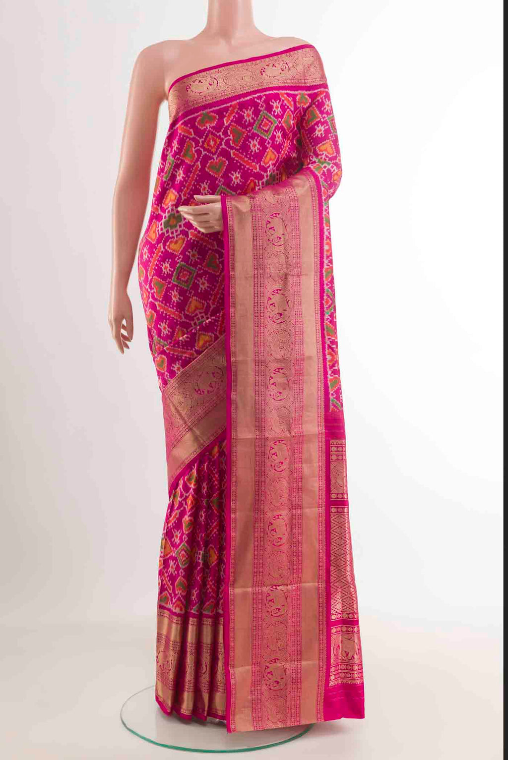 Rani Pink Rajkot Patola Silk Saree with Pure Ikat on the body and Zari Border.  displayed on a mannequin