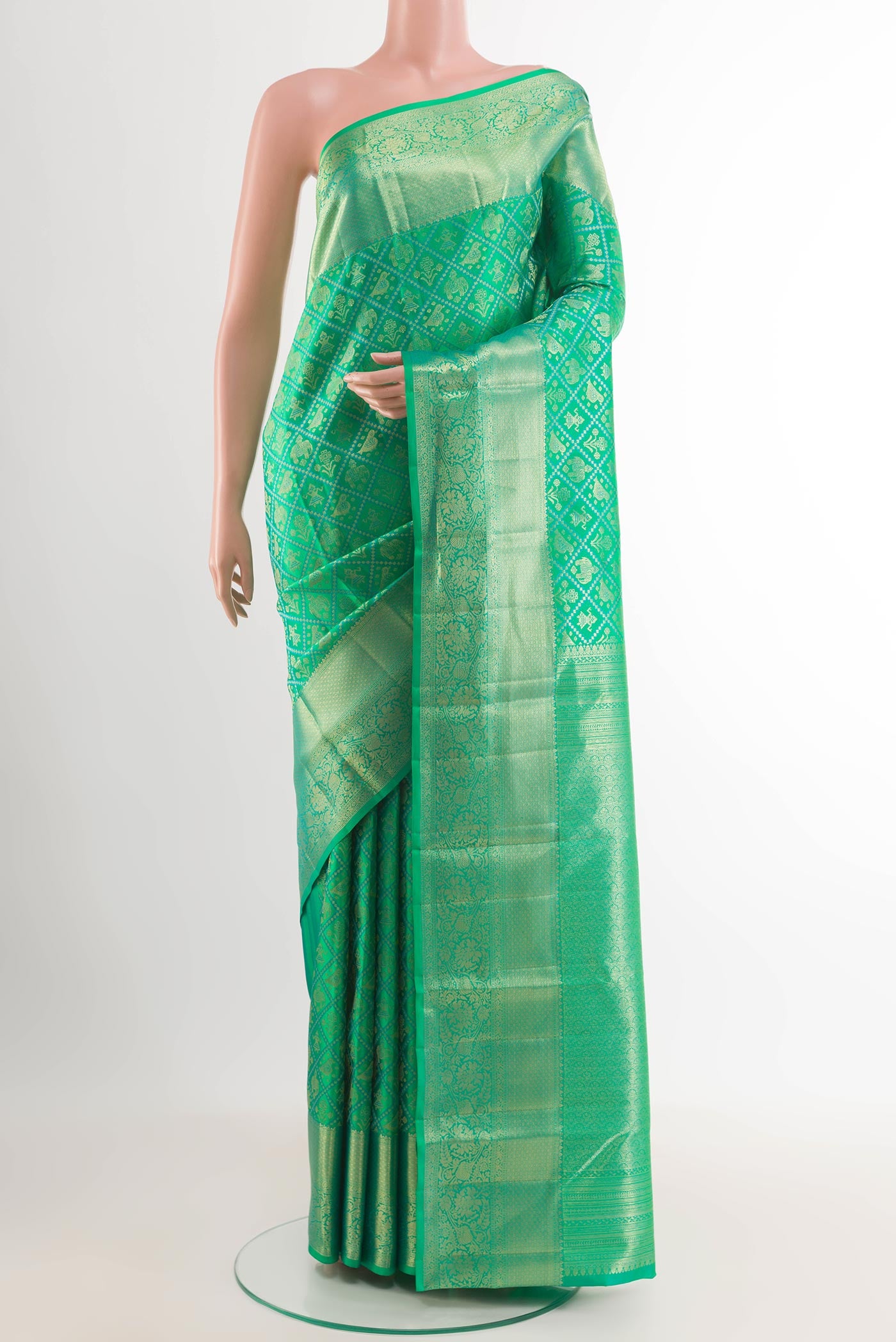 Green Kanchipuram Silk Saree with Zari Brocade on the body and Plain Border.  displayed on a mannequin