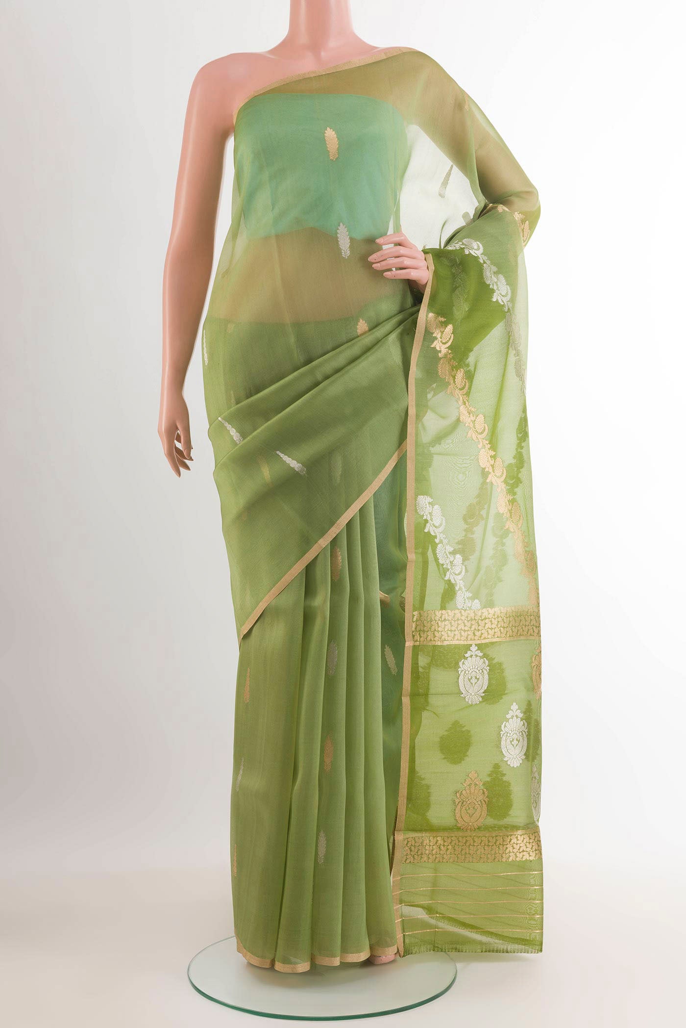 Green Banarasi Kora Silk Saree with Zari Butta on the body and Zari Border.  displayed on a mannequin