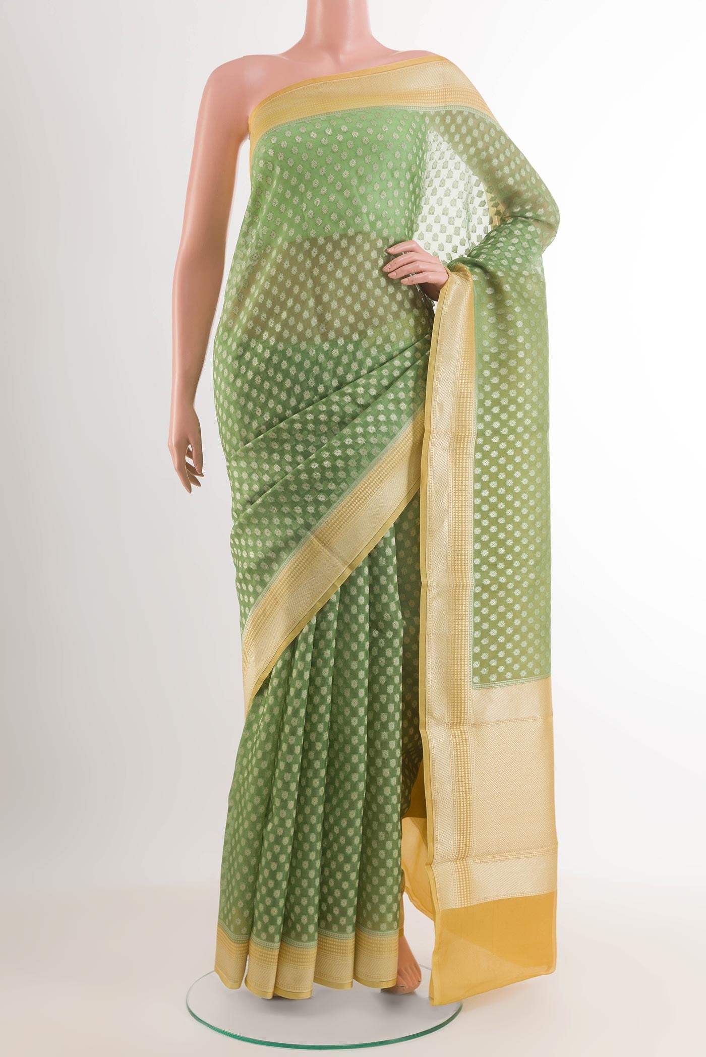 Green Banarasi Kora Silk Saree with Zari Butta on the body and Zari Border.  displayed on a mannequin