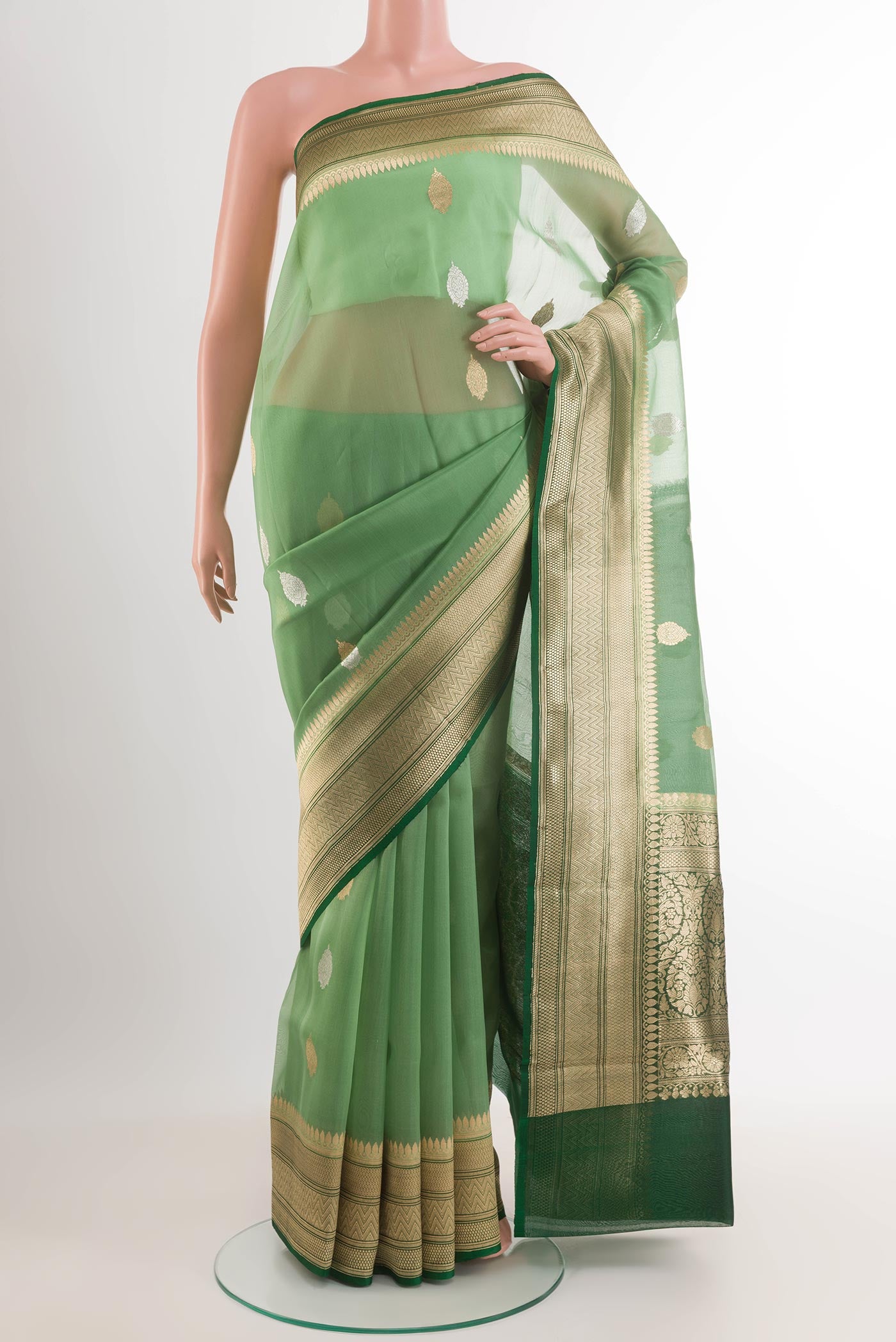 Green Banarasi Kora Silk Saree with Zari Butta on the body and Zari Border.  displayed on a mannequin