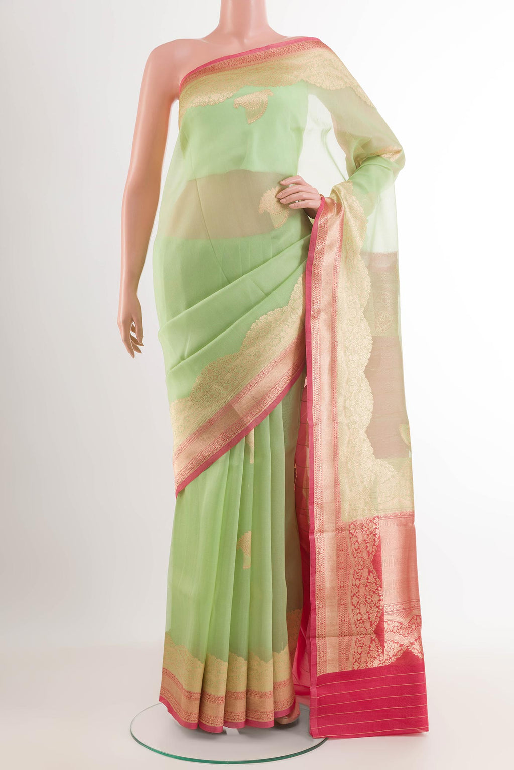 Green Banarasi Kora Silk Saree with Zari Butta on the body and Zari Border.  displayed on a mannequin