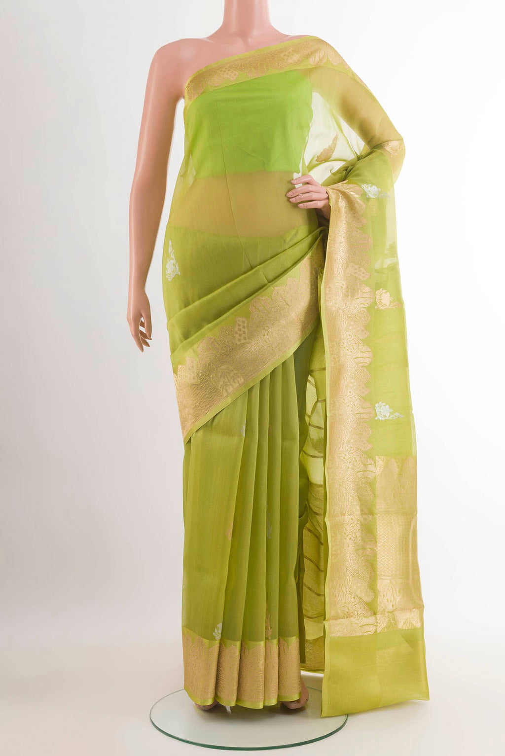 Green Banarasi Kora Silk Saree with Zari Butta on the body and Zari Border.  displayed on a mannequin
