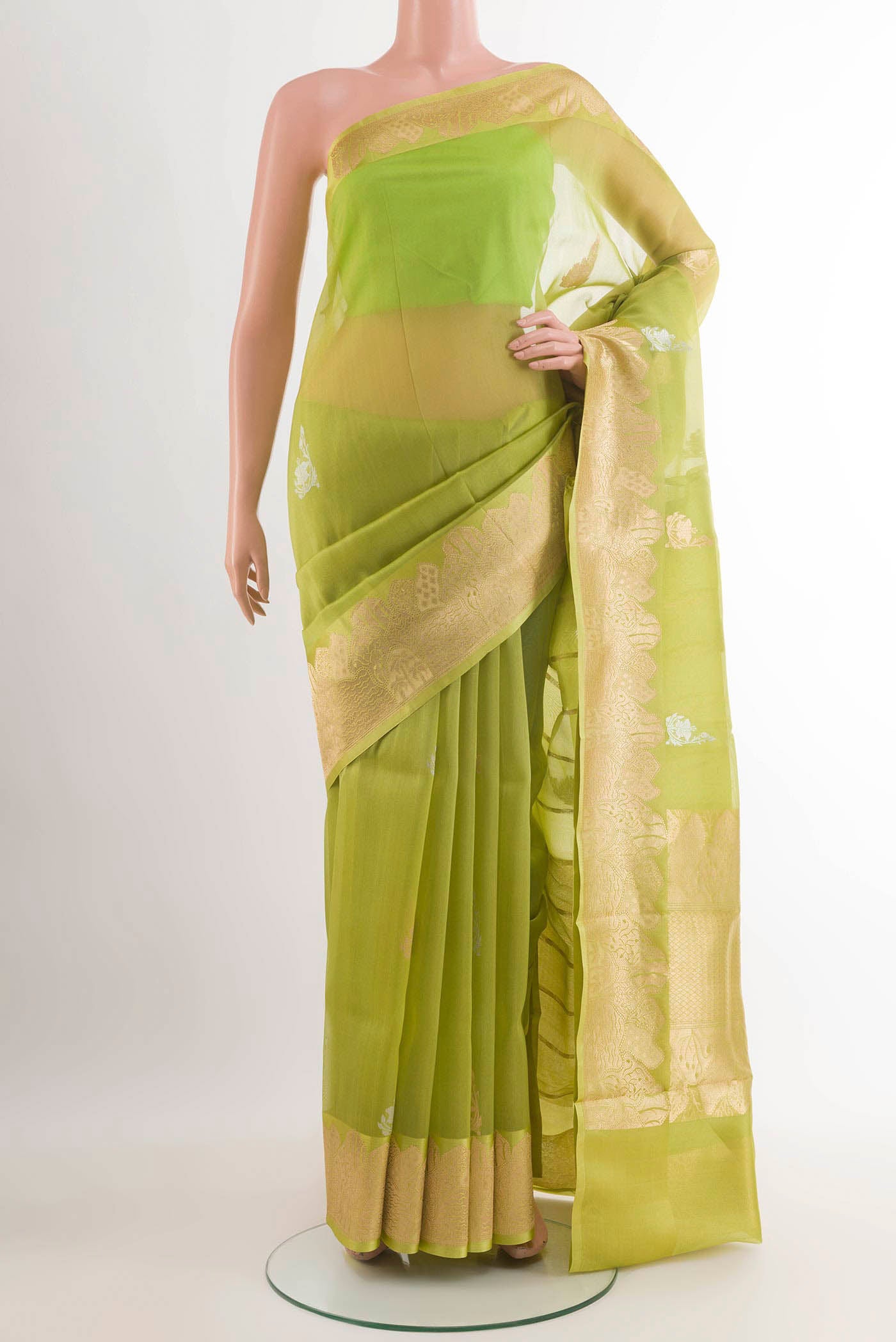 Green Banarasi Kora Silk Saree with Zari Butta on the body and Zari Border.  displayed on a mannequin