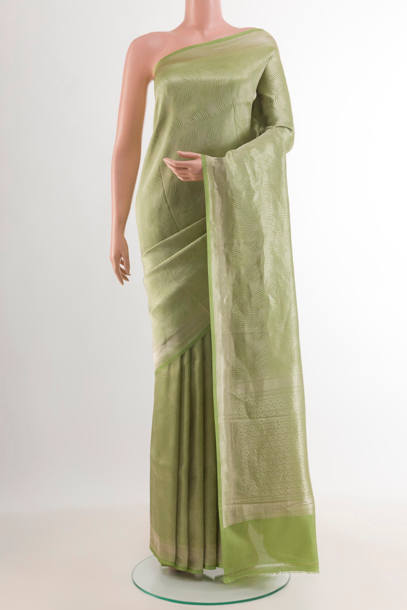 Green Crepe Saree with Zari Brocade on the body and Zari Border.  displayed on a mannequin