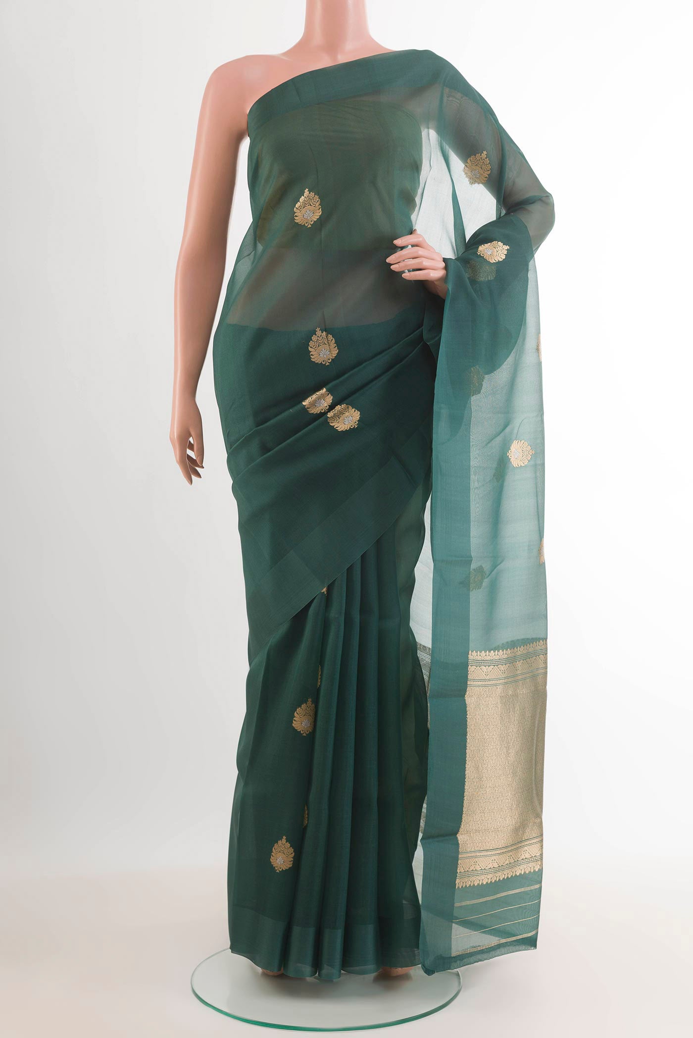 Bottle Green Banarasi Kora Silk Saree with Zari Butta on the body and Zari Border.  displayed on a mannequin