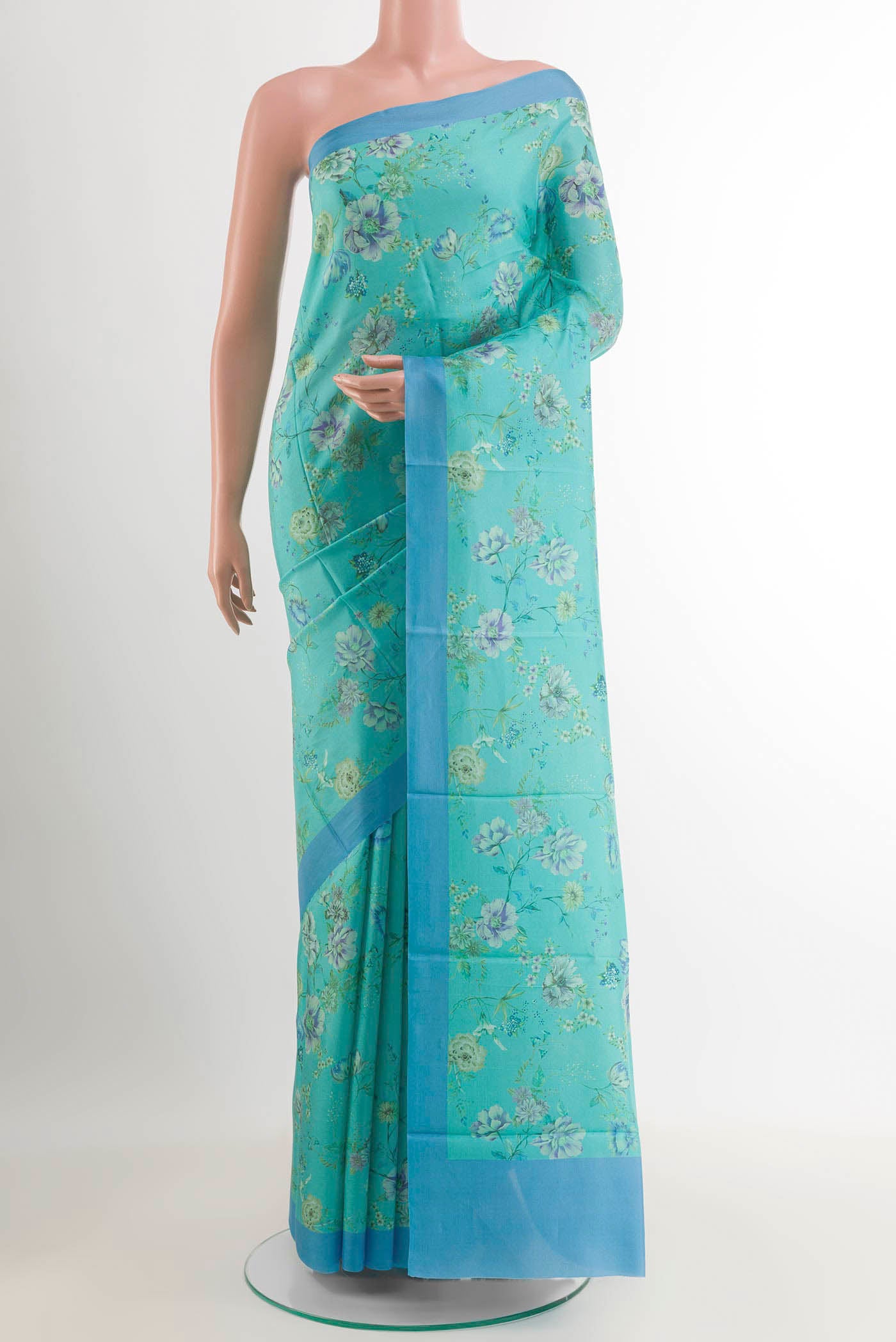 Blue Printed Silk Saree with Printed design on the body and Plain Border.  displayed on a mannequin