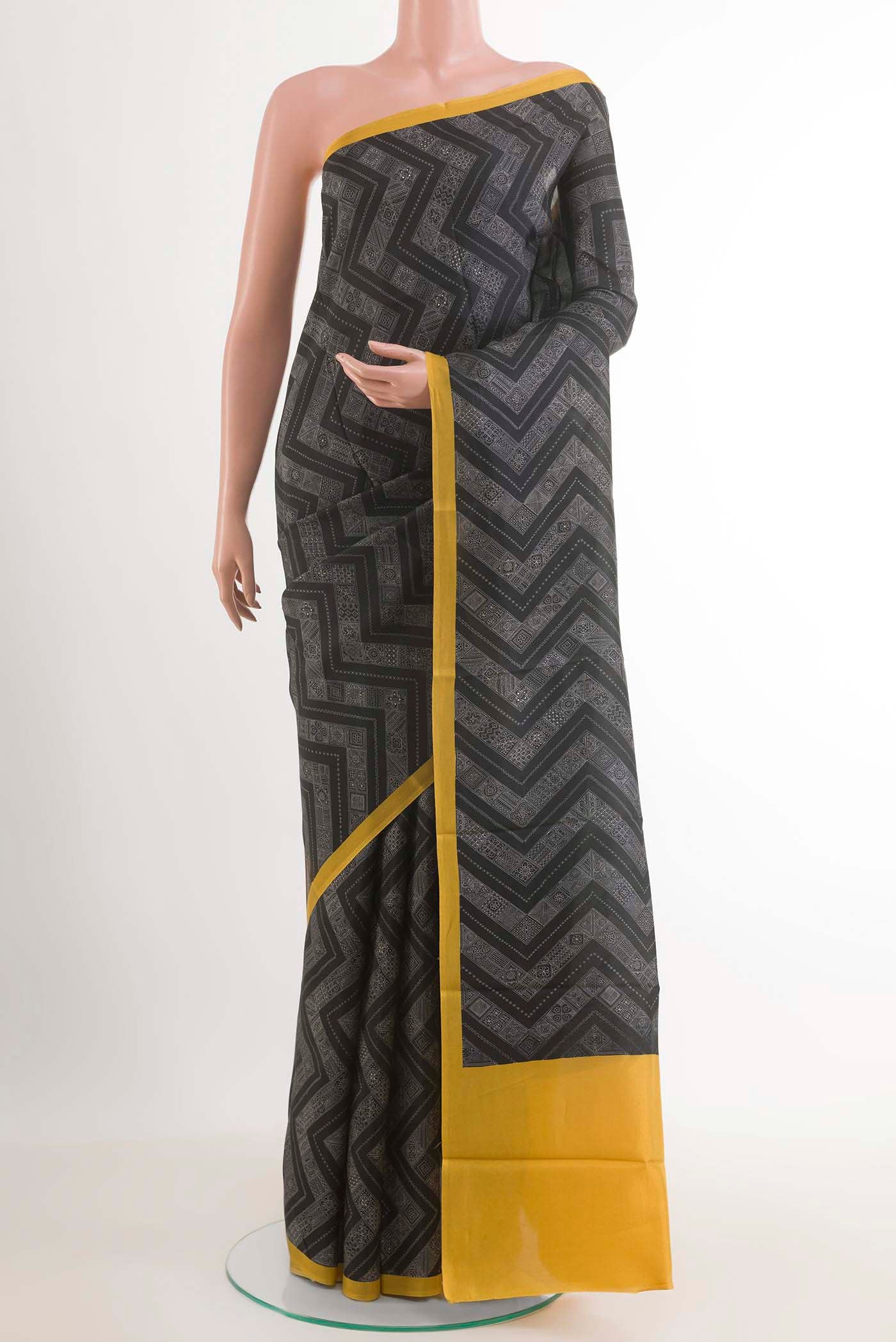 Black Printed Silk Saree with Printed design on the body and Plain Border.  displayed on a mannequin