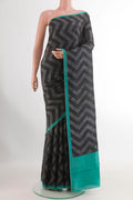 Black Printed Silk Saree with Printed design on the body and Printed Border.  displayed on a mannequin