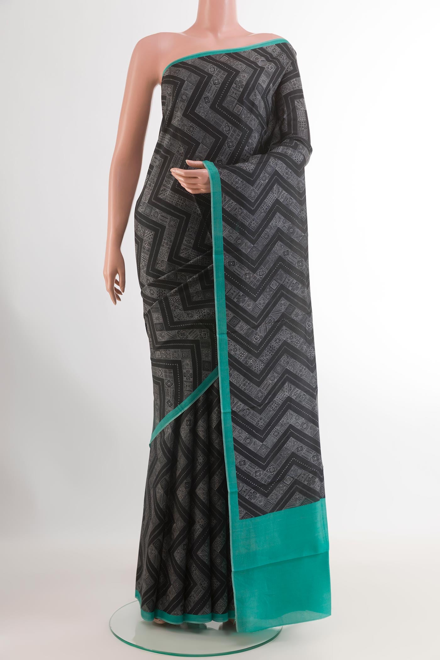 Black Printed Silk Saree with Printed design on the body and Printed Border.  displayed on a mannequin
