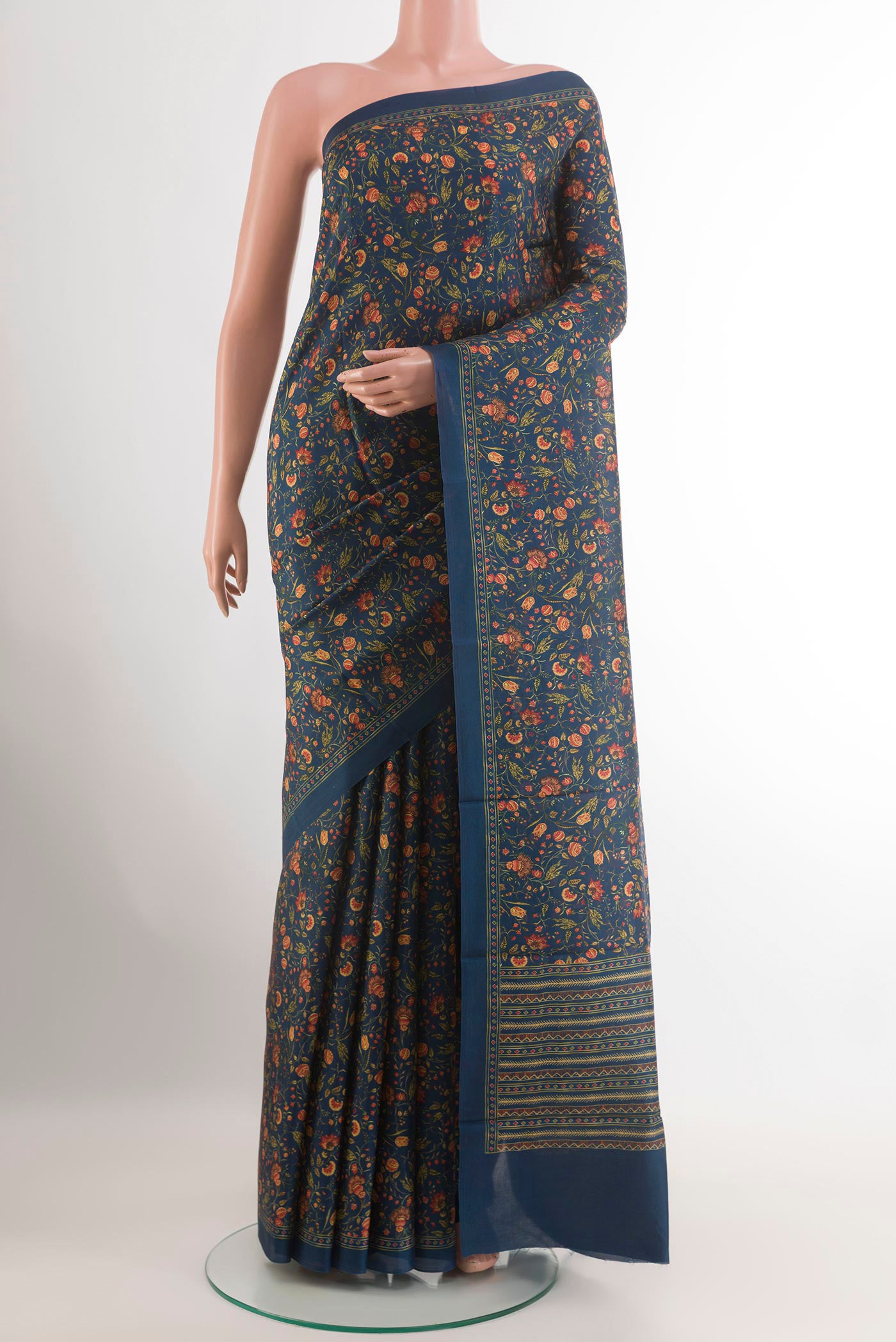 Blue Printed Silk Saree with Printed design on the body and Plain Border.  displayed on a mannequin